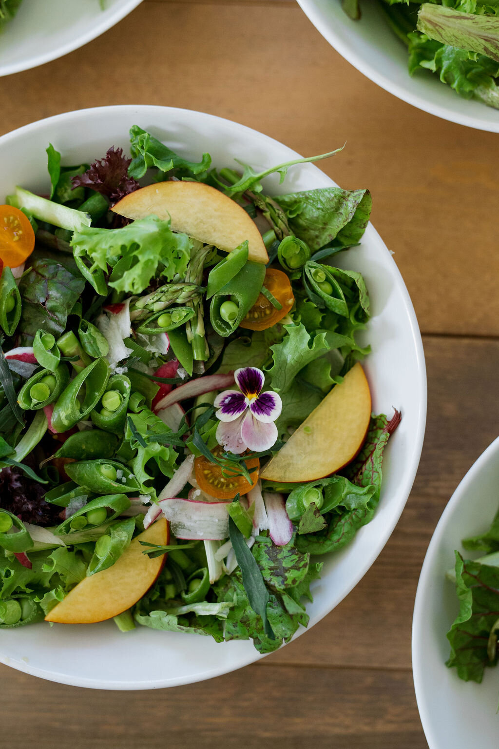 green salad with nectarines, flowers and peas