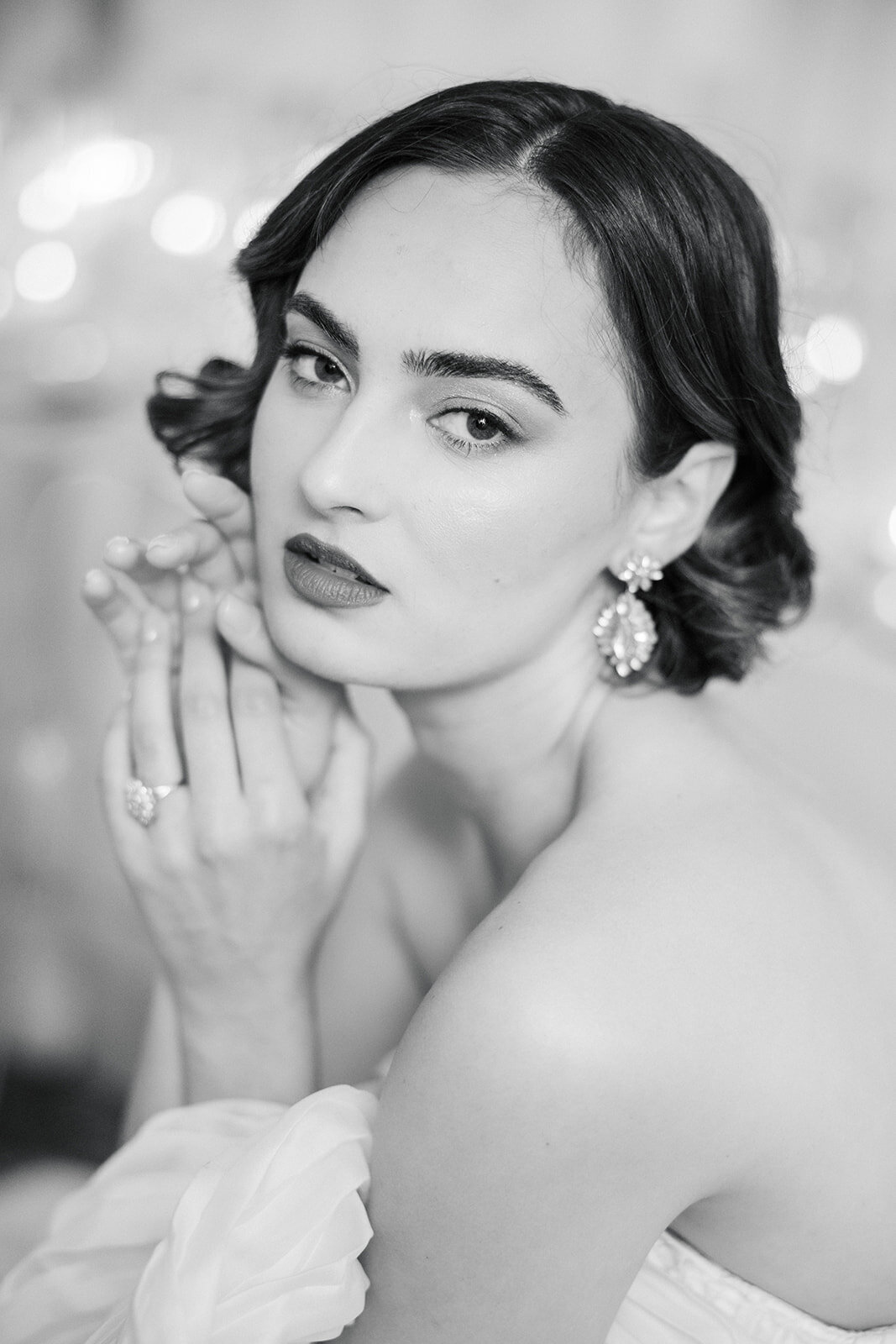 Classic regal brunette bride gazes intently with hands up and neoclassical engagement ring
