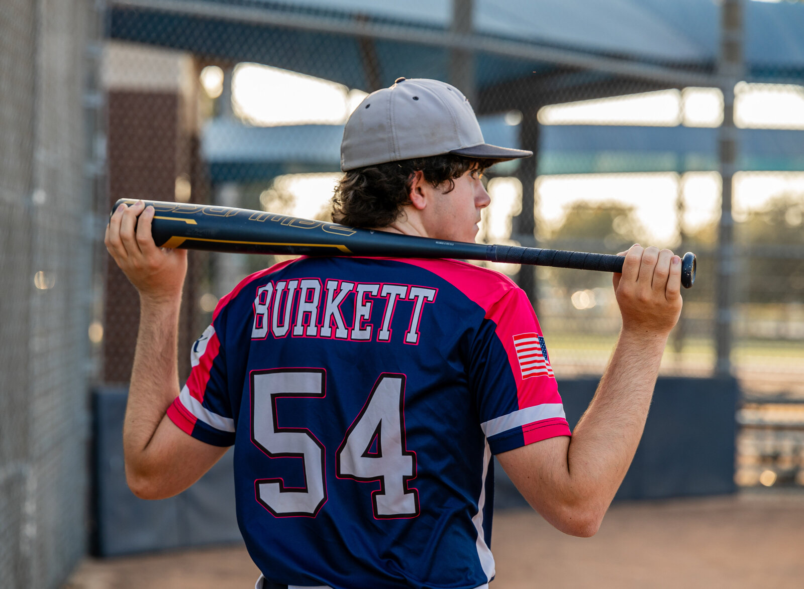 senior boy with bat at baseball field