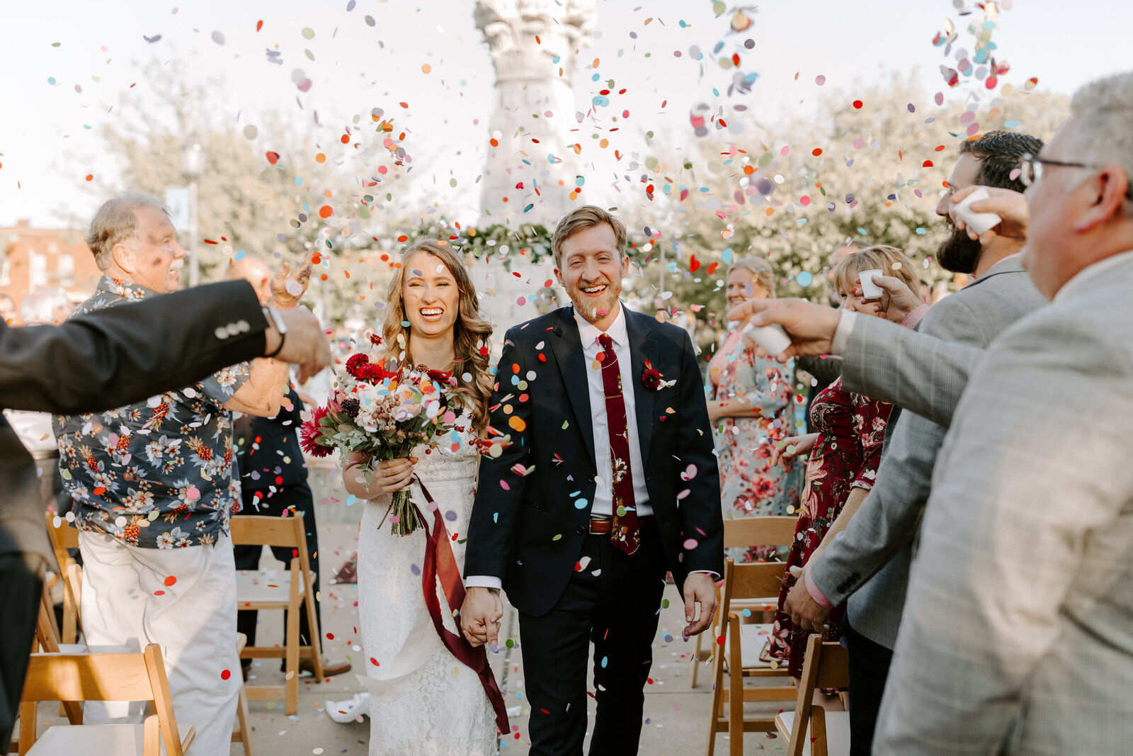 Bride and groom exit wedding ceremony with confetti around them at wedding in Lafayette Square