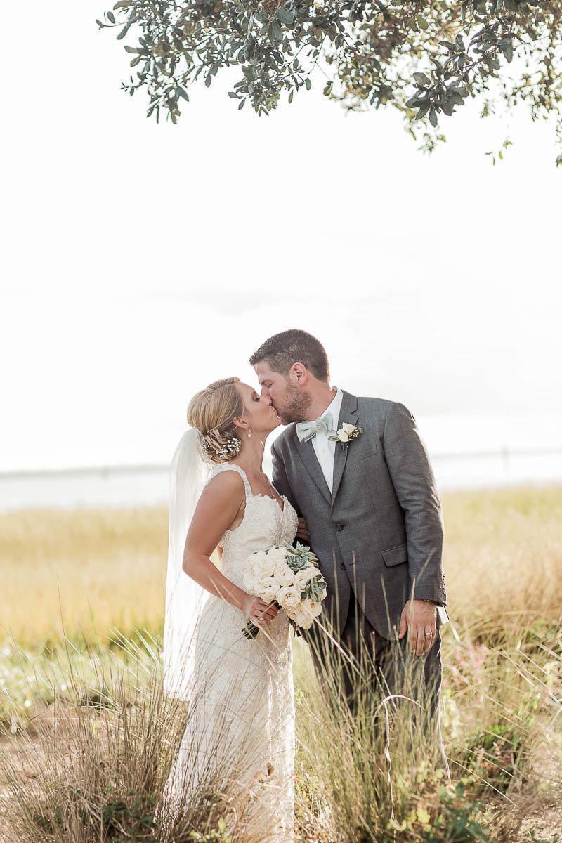 Bride and groom stand in tall grass, Alhambra Hall, Mt Pleasant, South Carolina