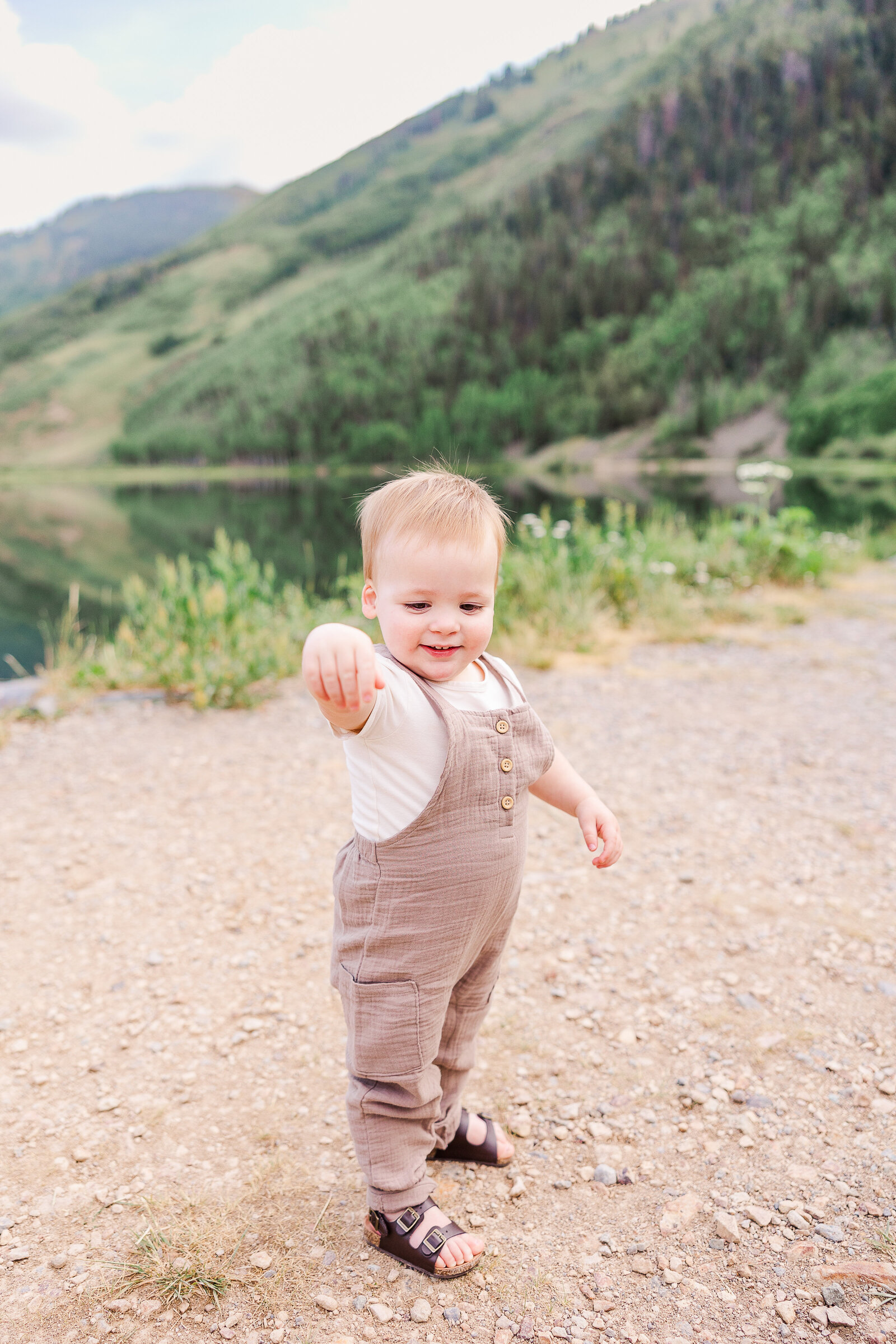 one year old throws rock and giggles