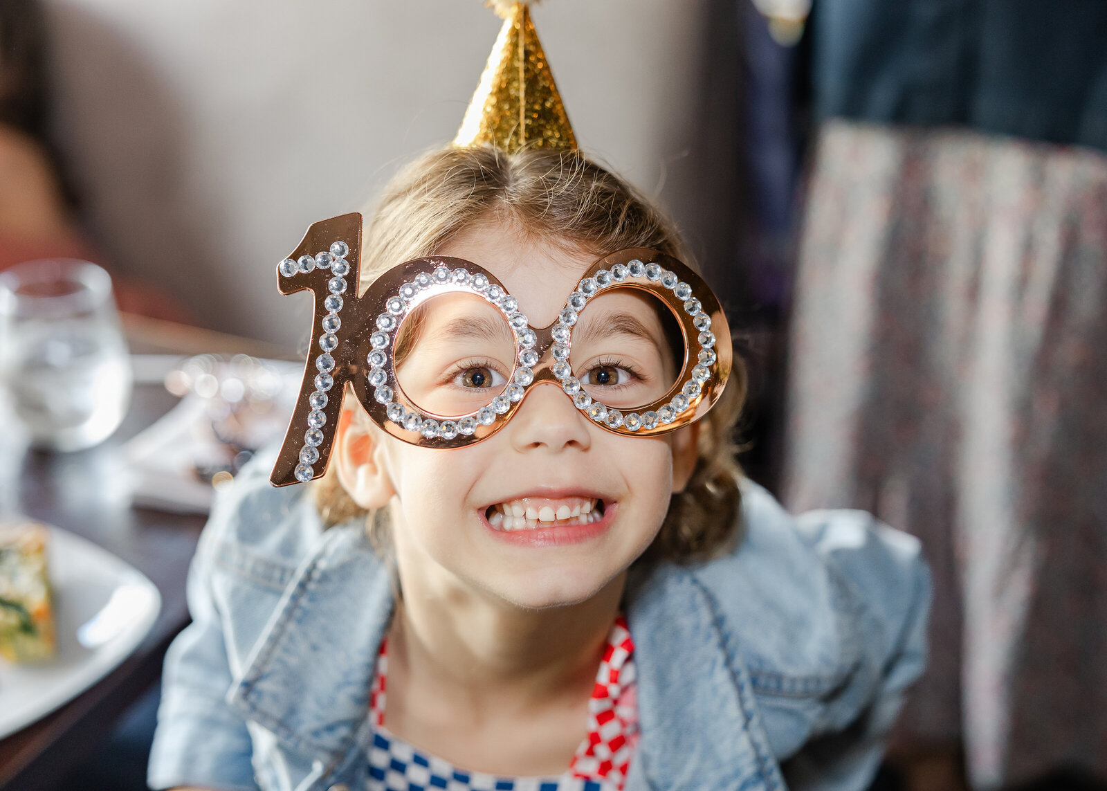A young guest wears "100" glasses while celebrating her great grandmother.