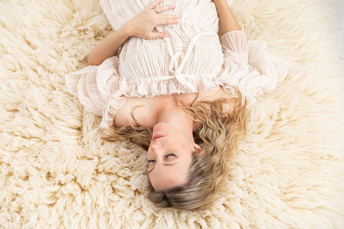 Pregnant woman laying on textured blanket for Maryland Maternity Photos