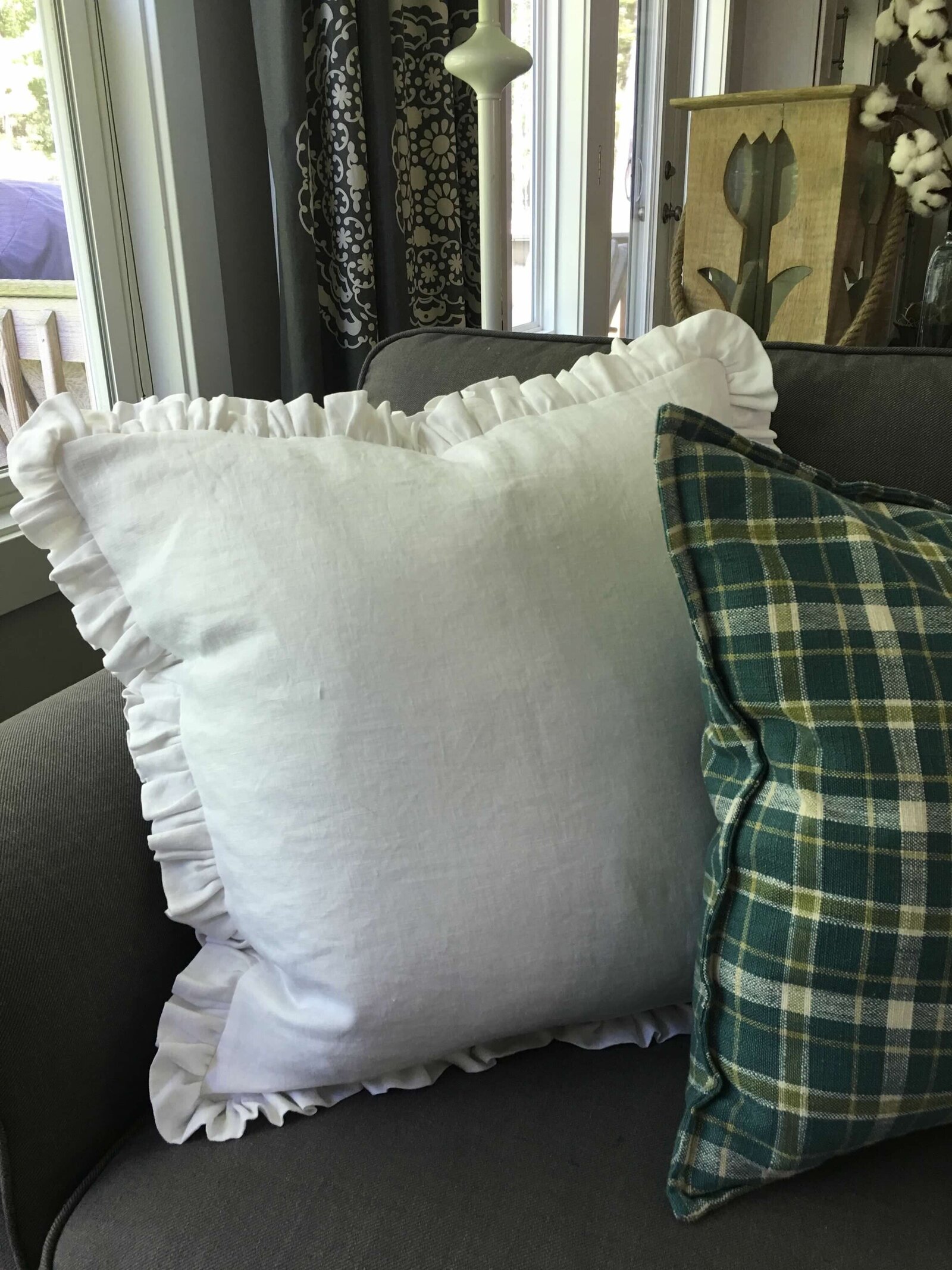 White linen ruffle pillow on a couch