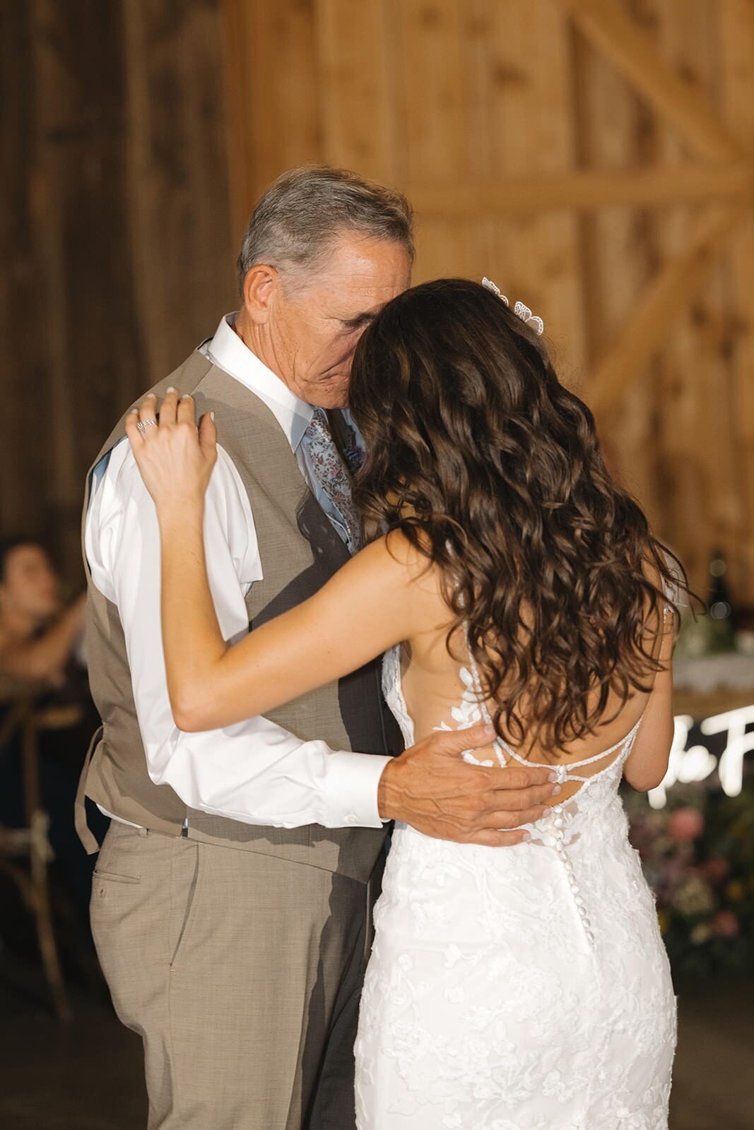 Bride dancing with her dad in the barn