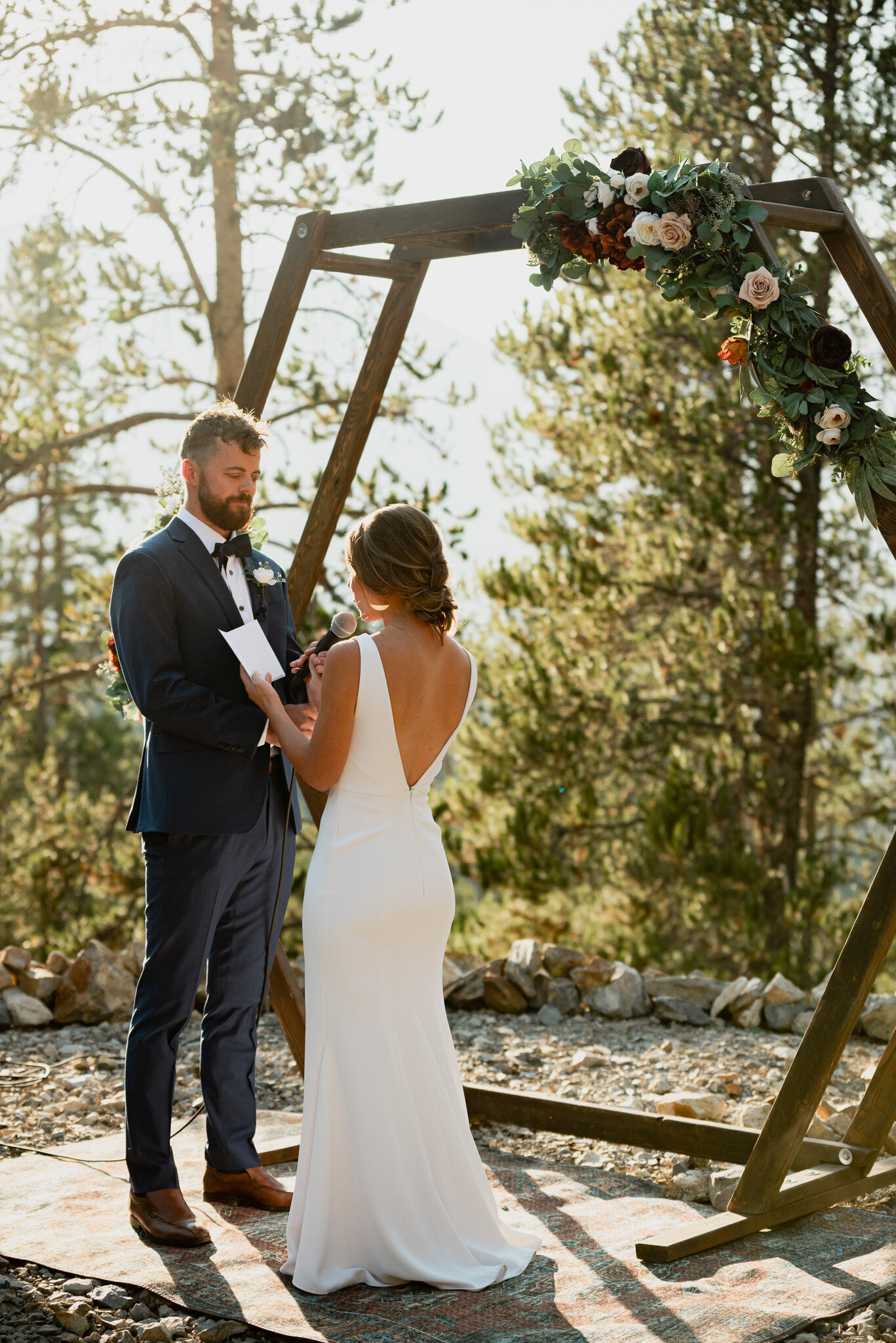 Professional photograph of bride and groom saying their vows at an outdoor alter.