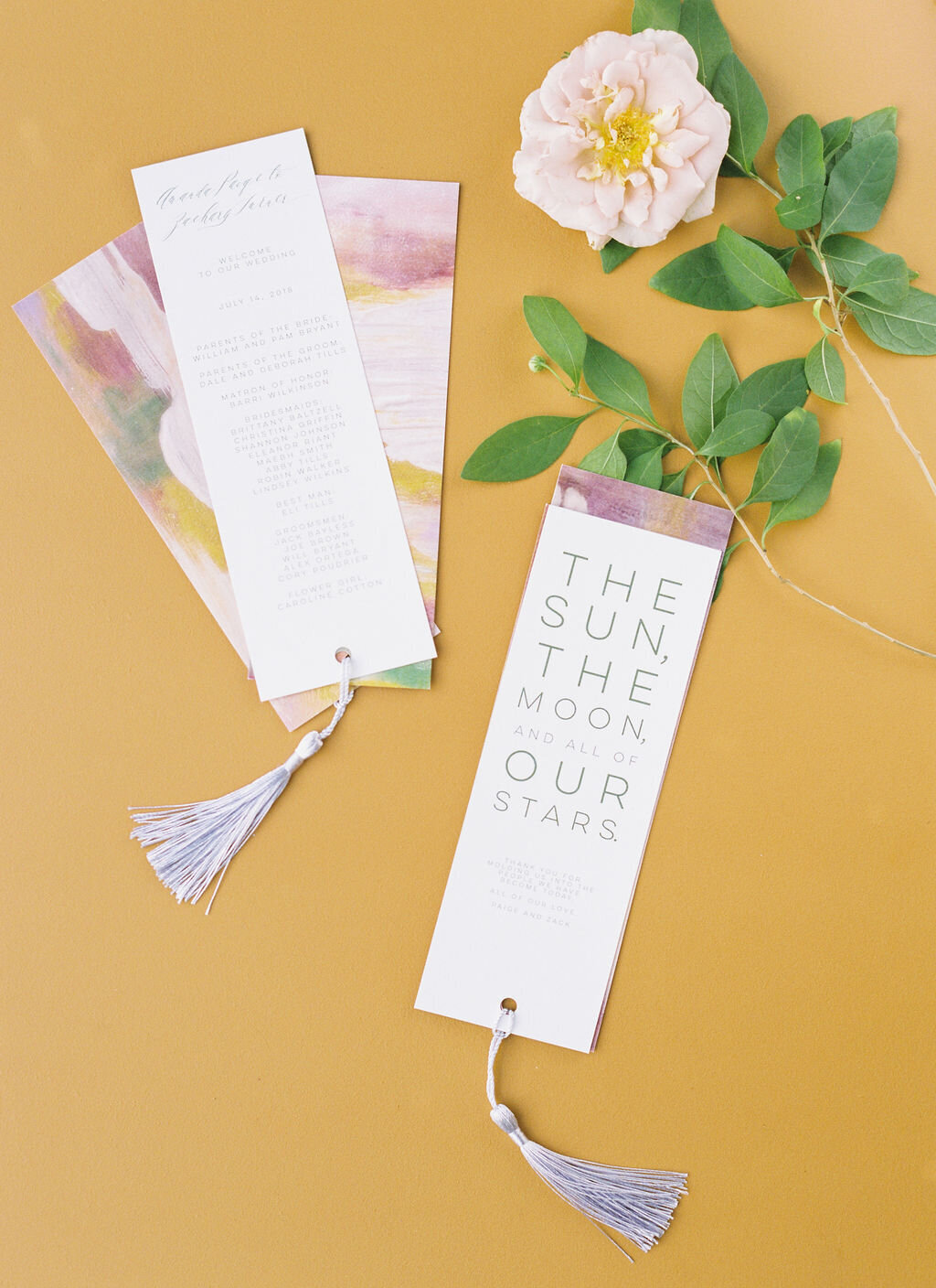 Flatlay of wedding  program  with mustard color background and watercolor details