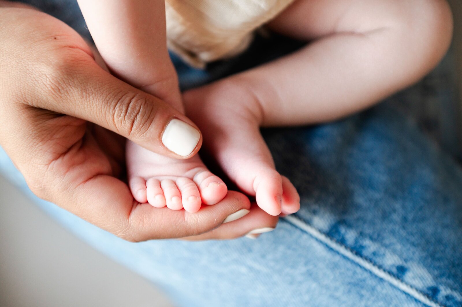 newborn baby feet in moms hand