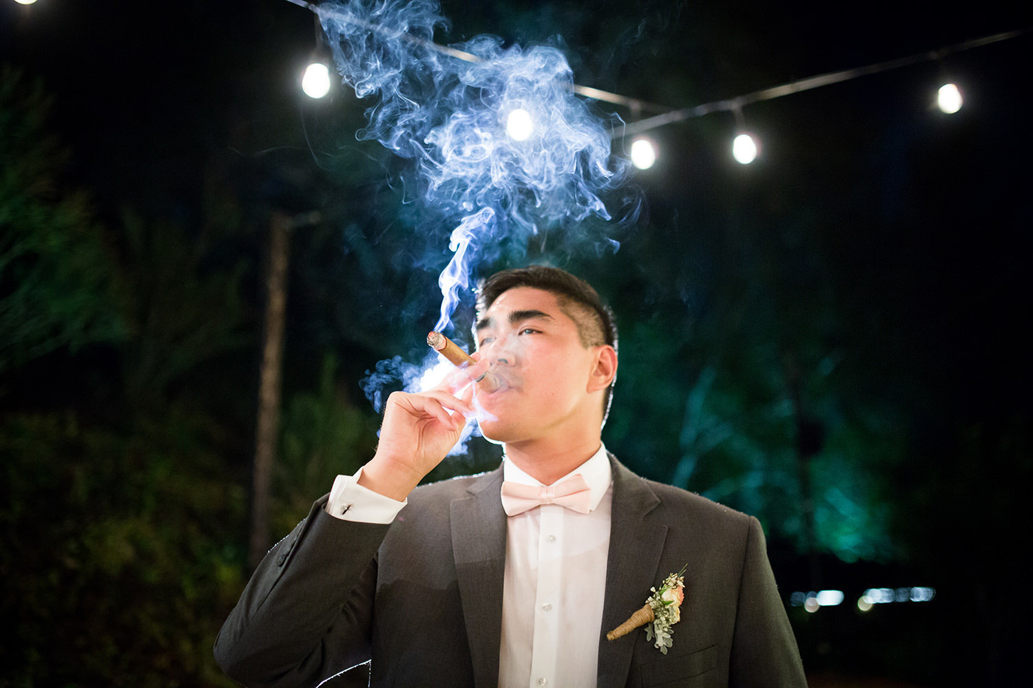 great nightshot of groom with cigar