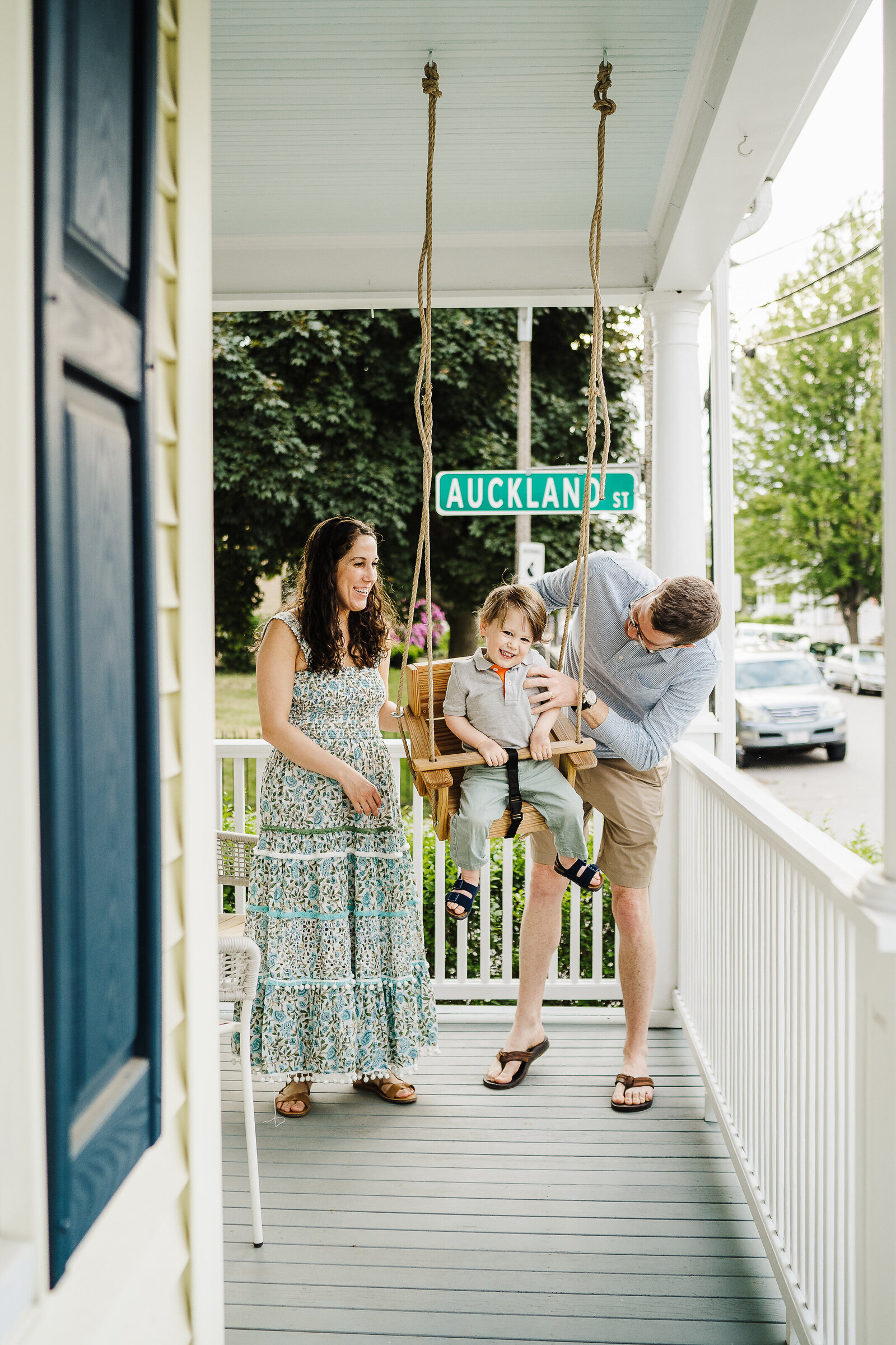 parents push toddler in porch swing