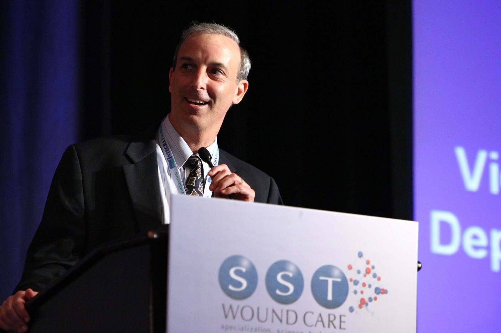 Presenter talking at podium of medical convention
