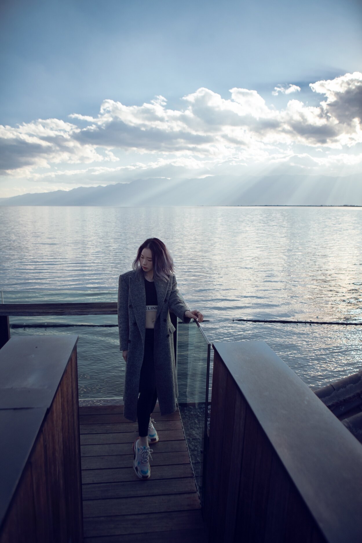 Tracy of 3N7LOVE photographed on a wharf with the water and mountains in the background.