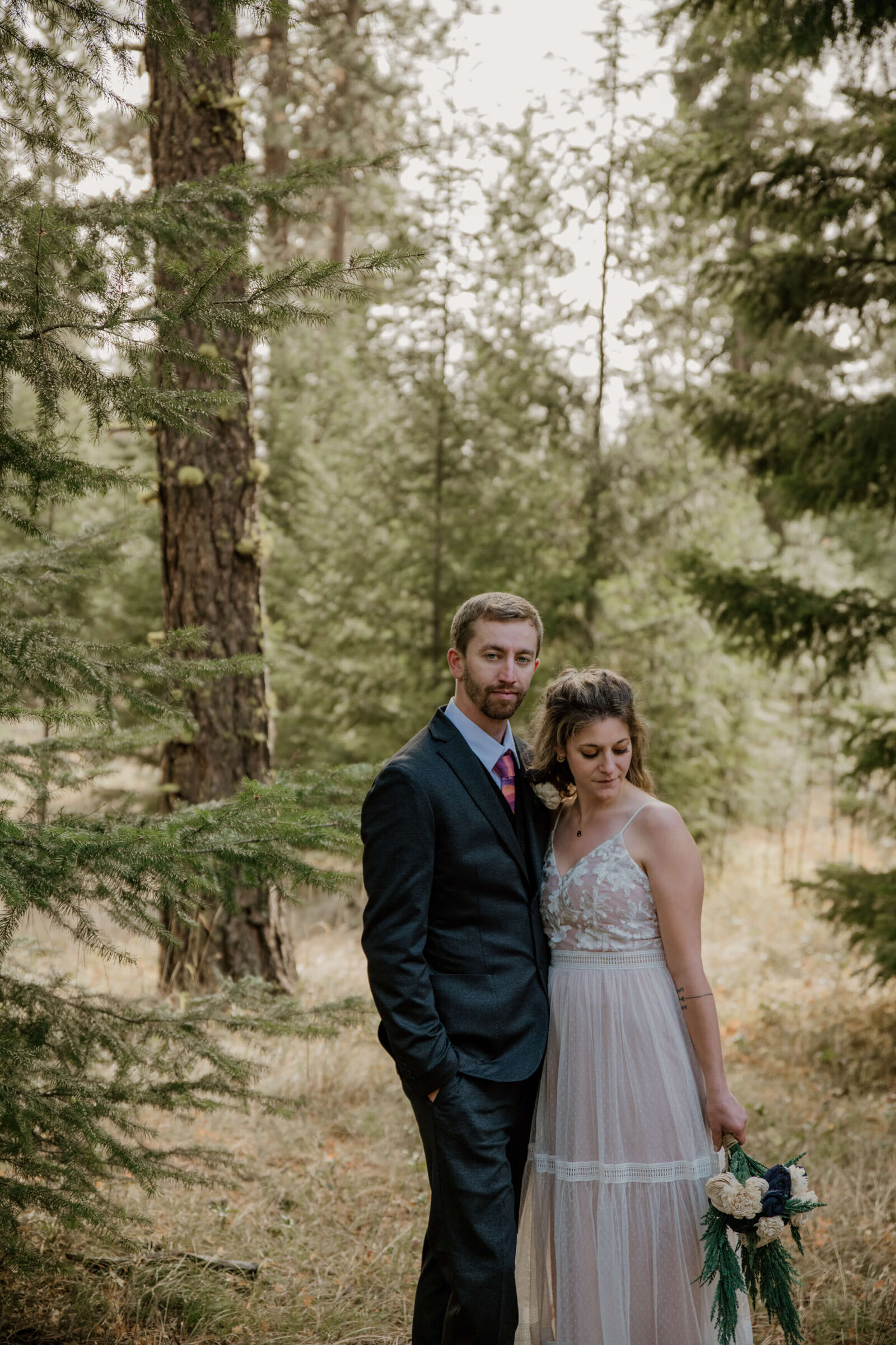 Groom and Bride standing in forest.