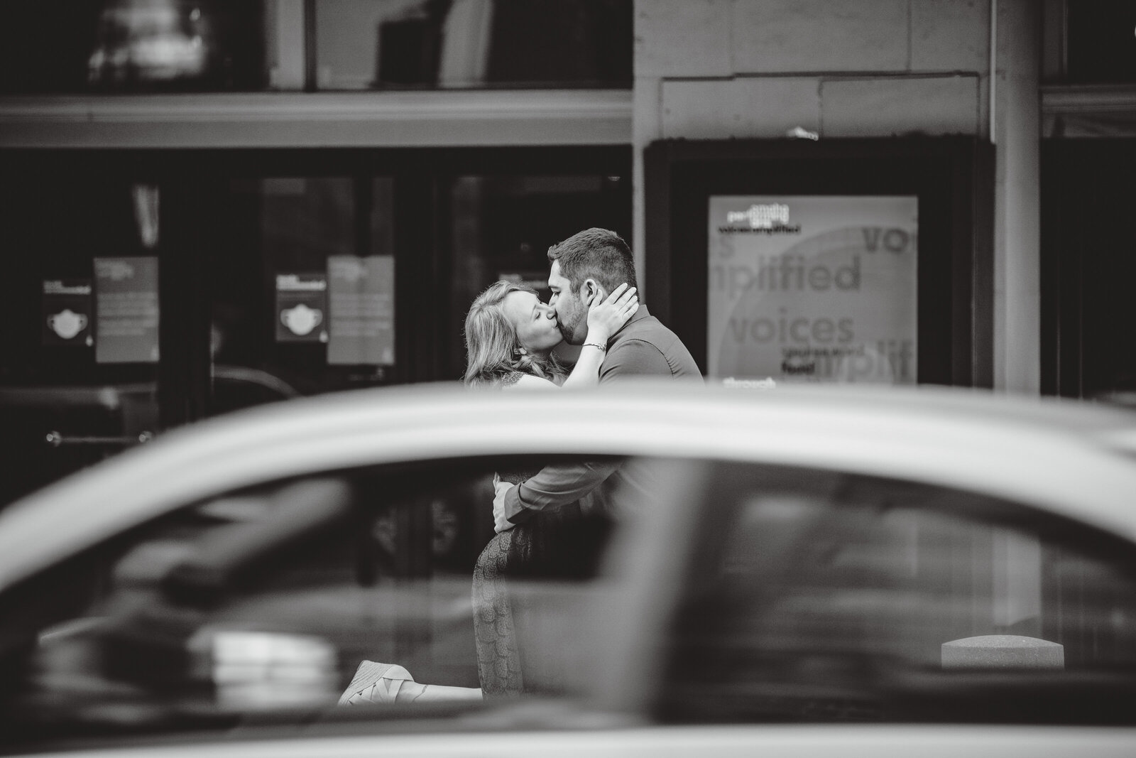 Couple kissing with car driving by