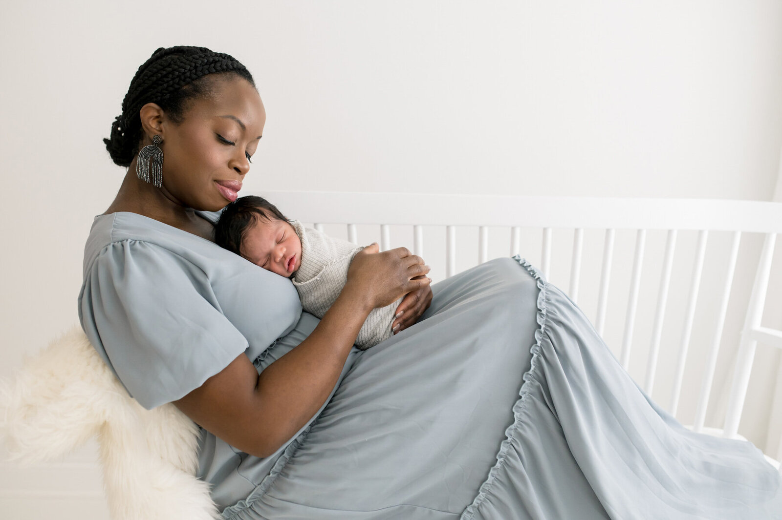 Mom holding newborn on bench