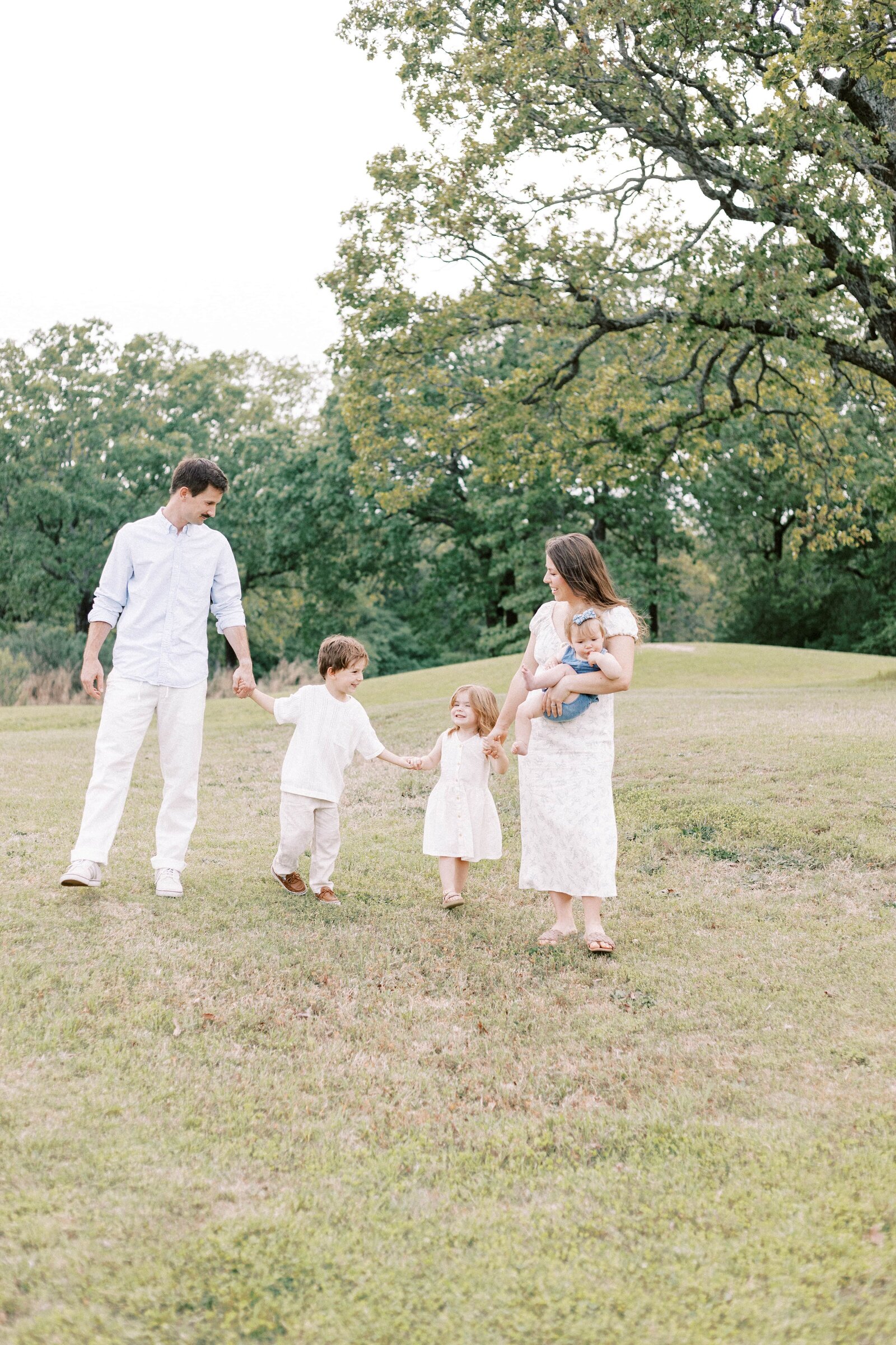 family holding hands and walking together during family photos in peoria illinois 