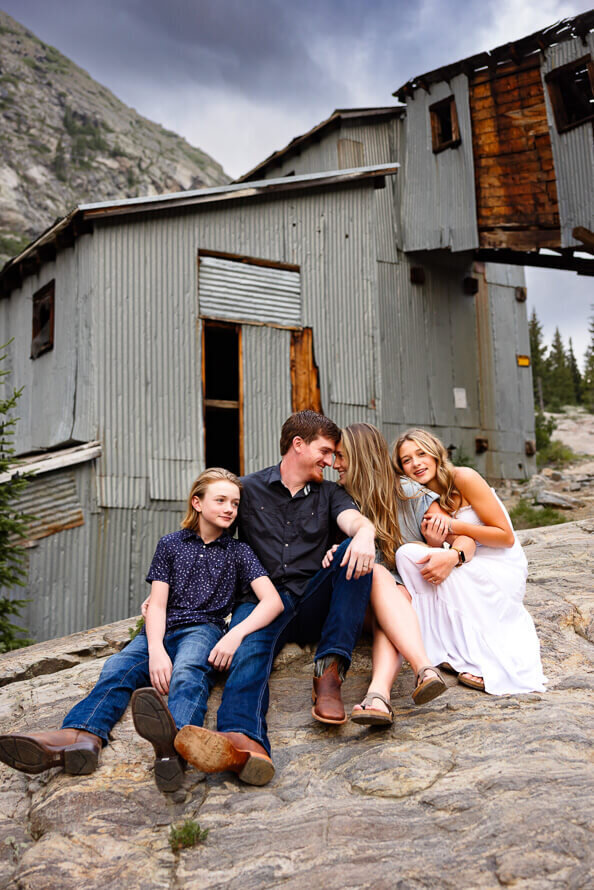Family of four snuggle together for their family photos in the mountains of Colorado.