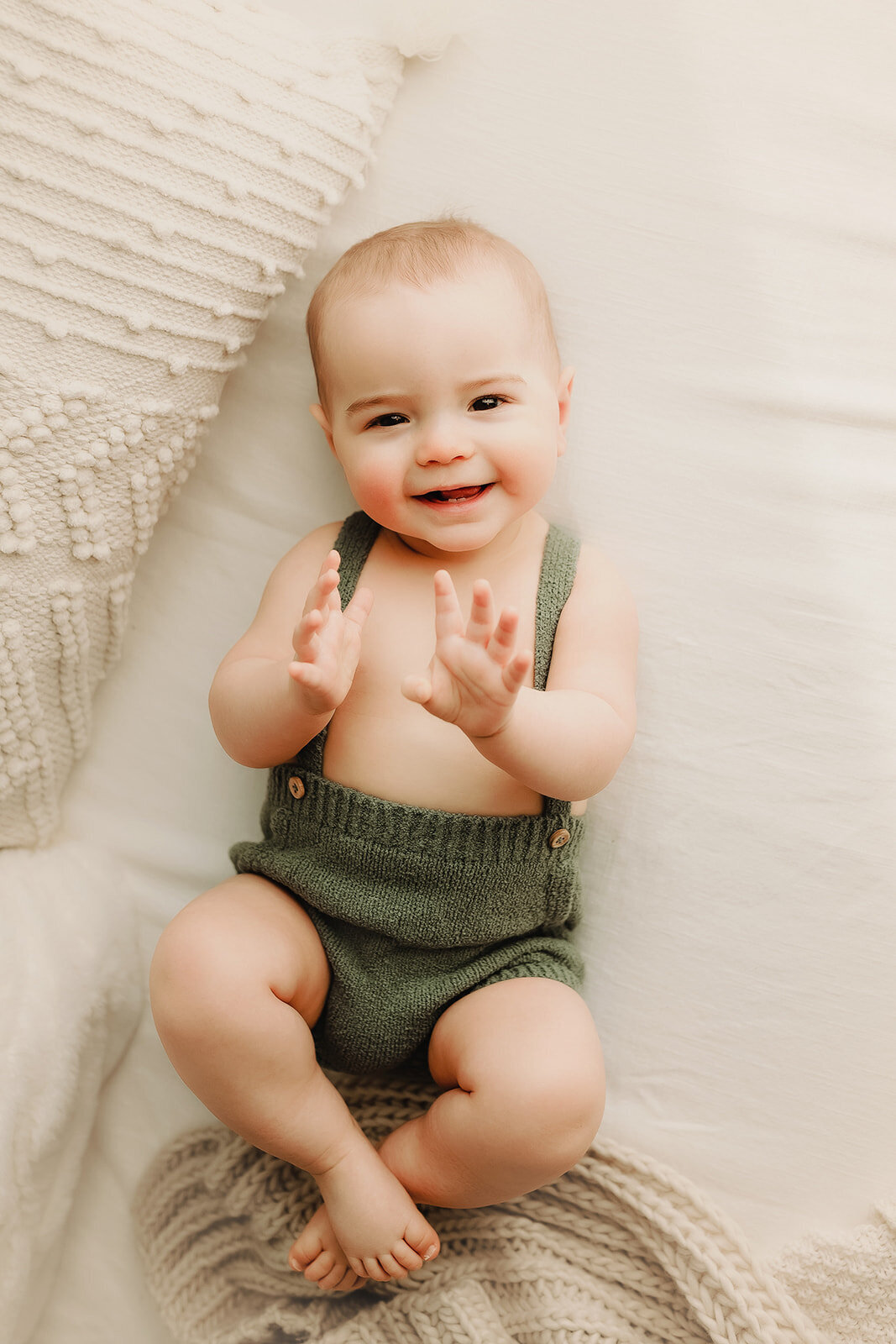a 3 month old baby boy smiles sweetly duiring his baby photography session