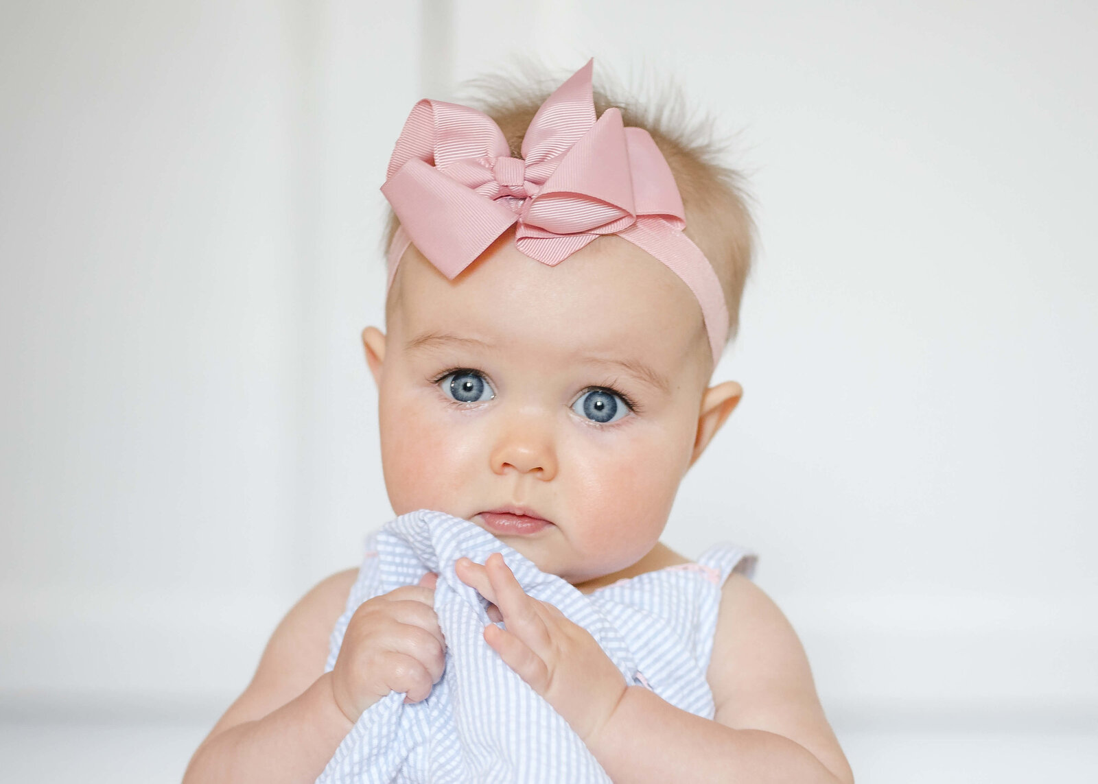 Bashful baby with oversized pink bow