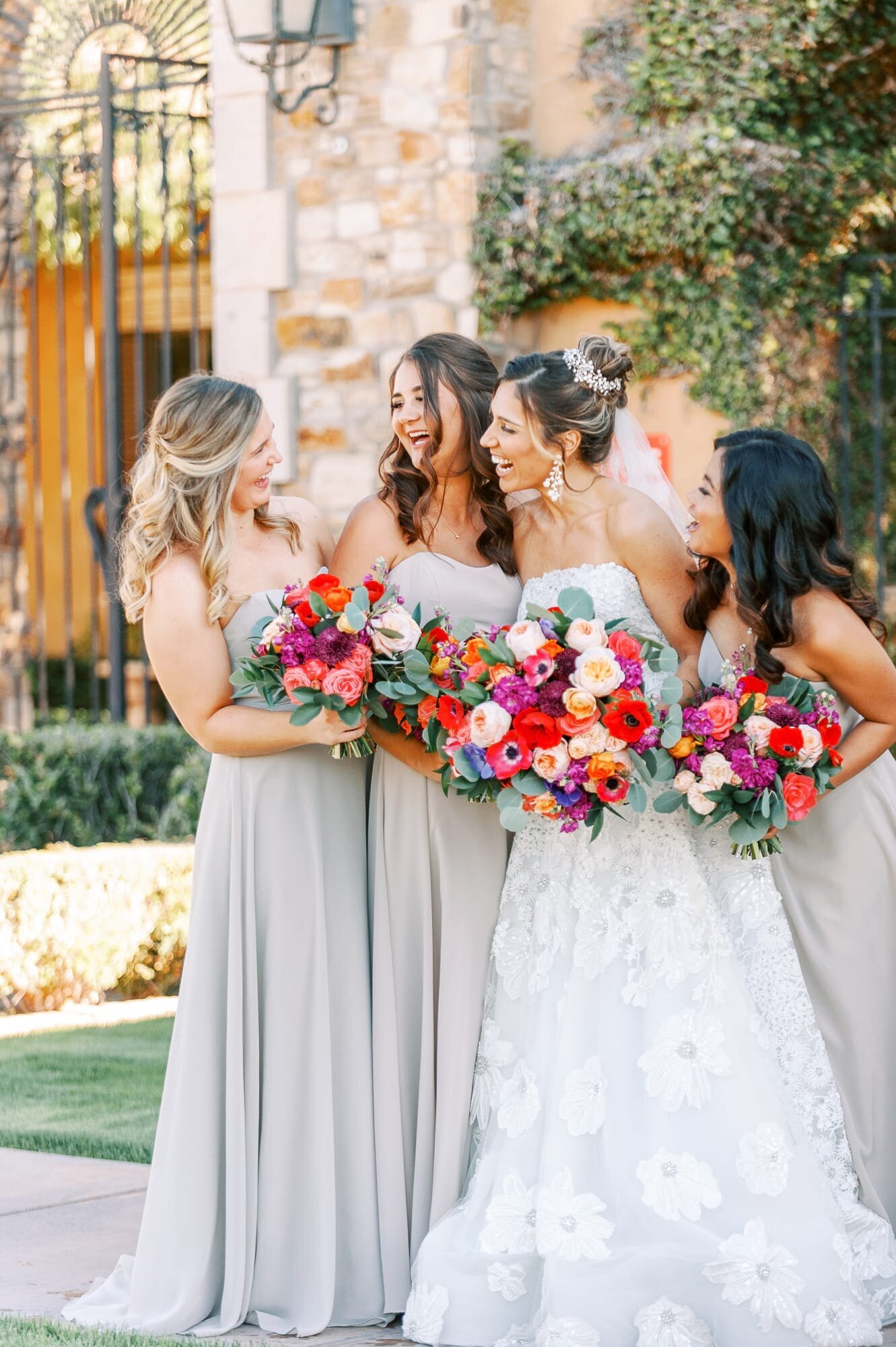The Bride and her bridesmaids laugh during portraits.