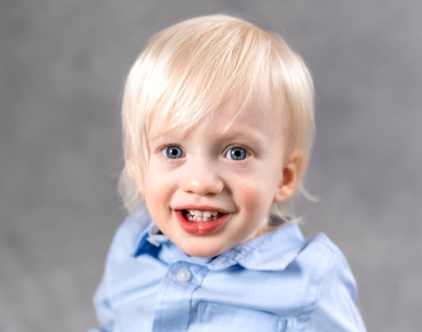A child smiles with blue eyes.