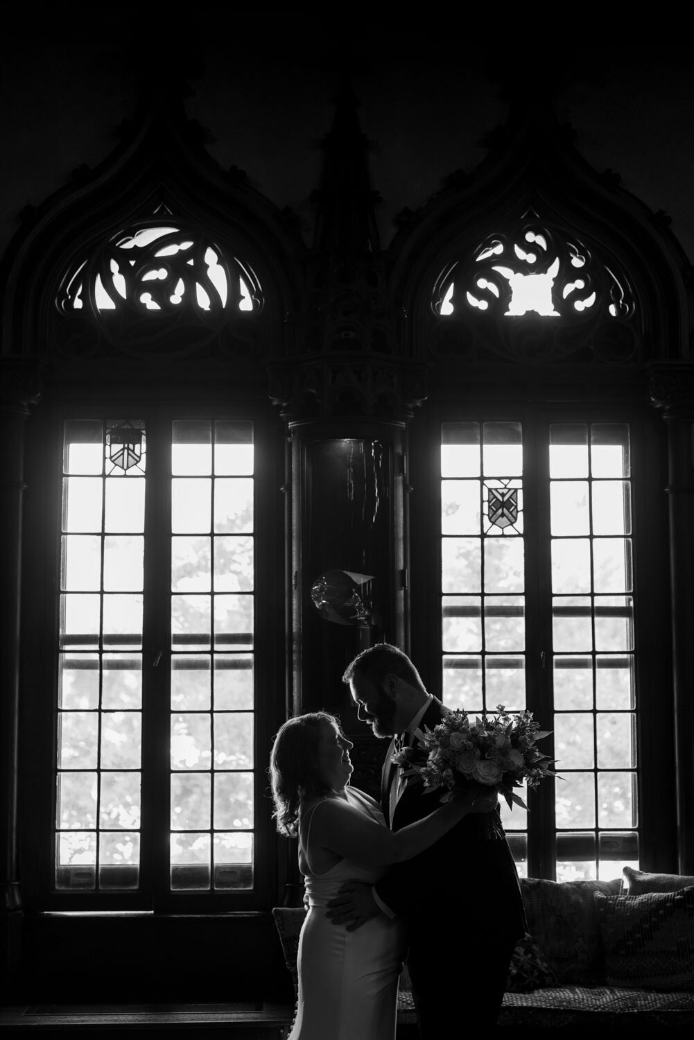 White and black photo of bride and groom about to kiss