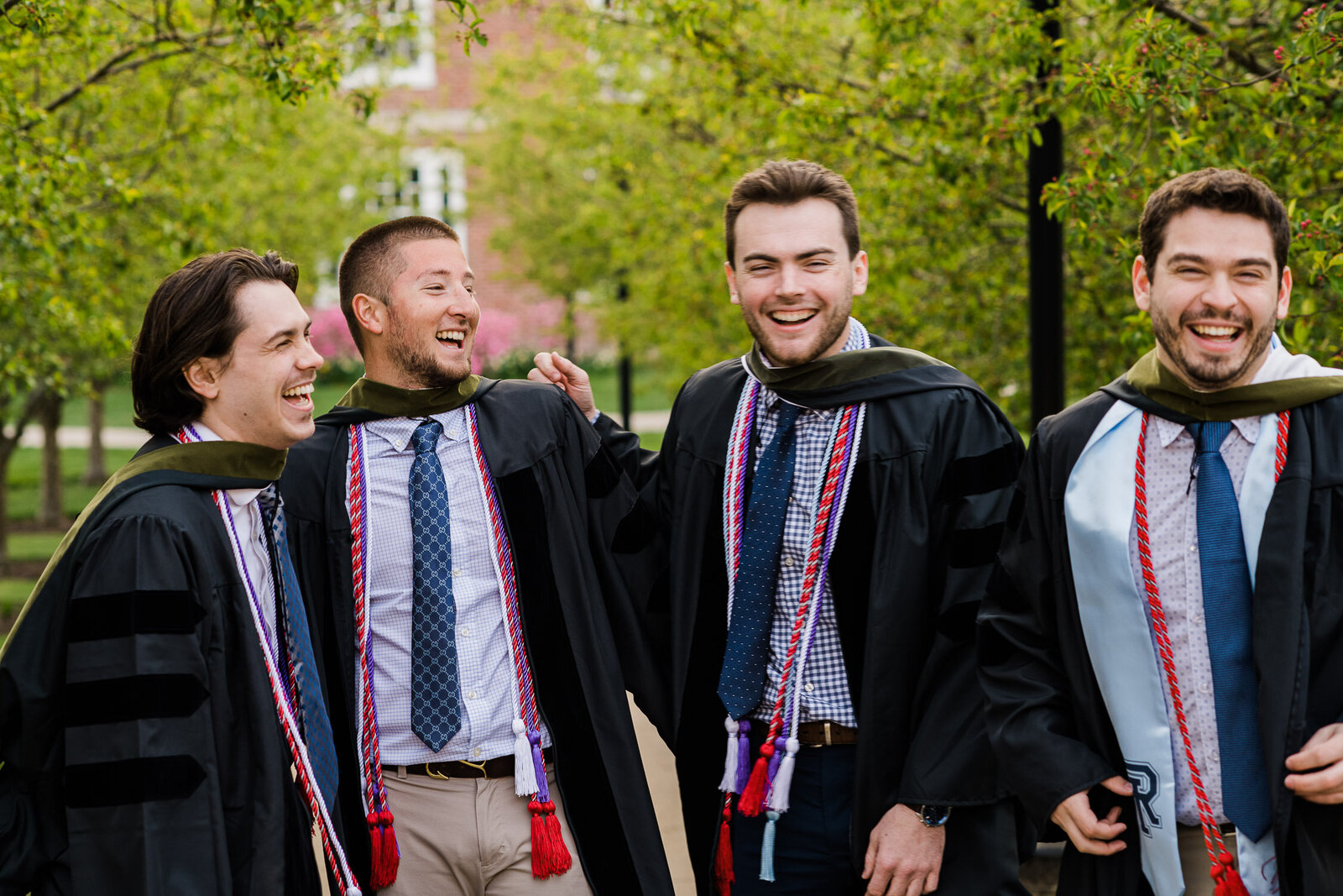 grad boys in robes with sashes playful