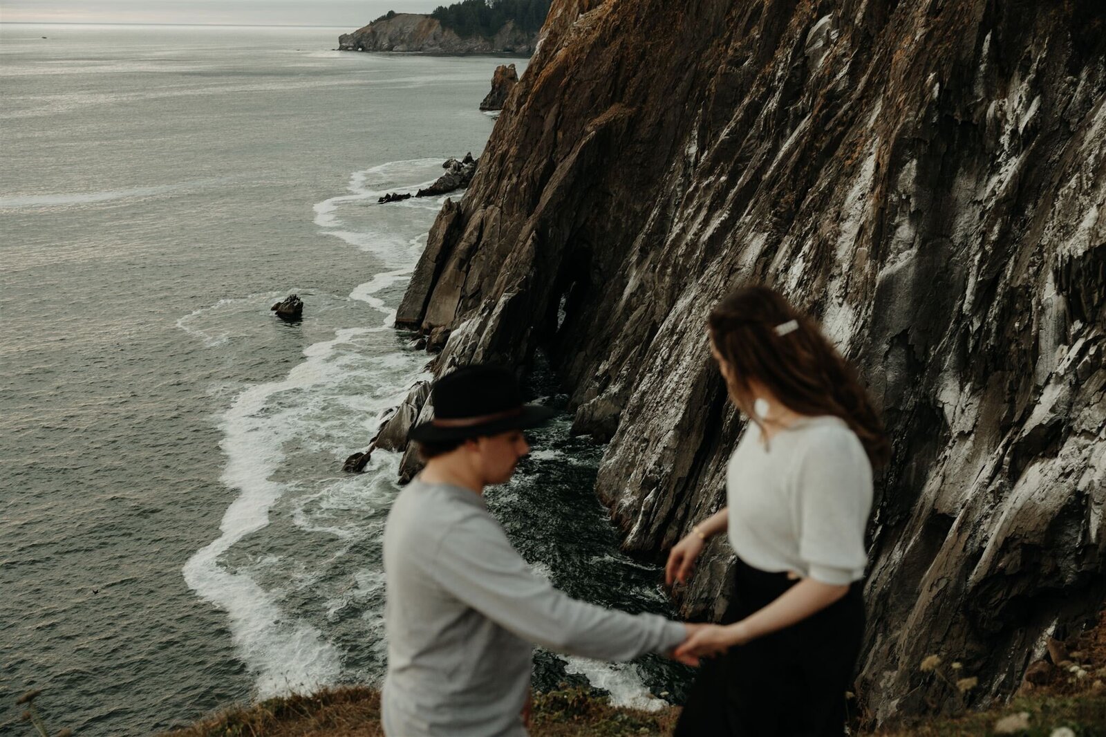 Adventurous engagement couple taking candid natural photos at the Oregon Coast
