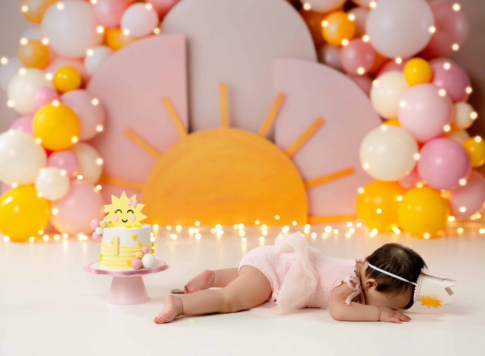 Baby on boho sunshine birthday set, face down on ground throwing a cute baby tantrum.