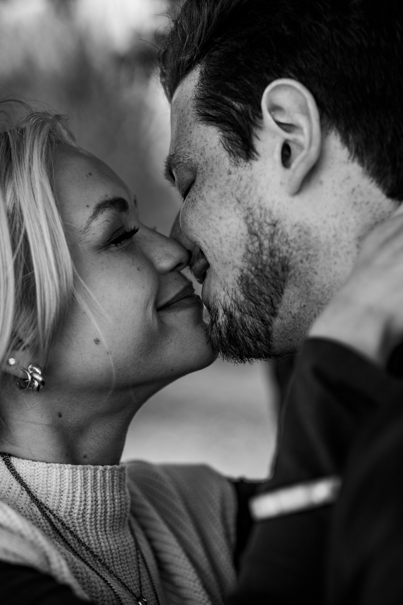Black and white engagement shot of Rachel and Blaine holding each other, sharing a tender moment, about to kiss.