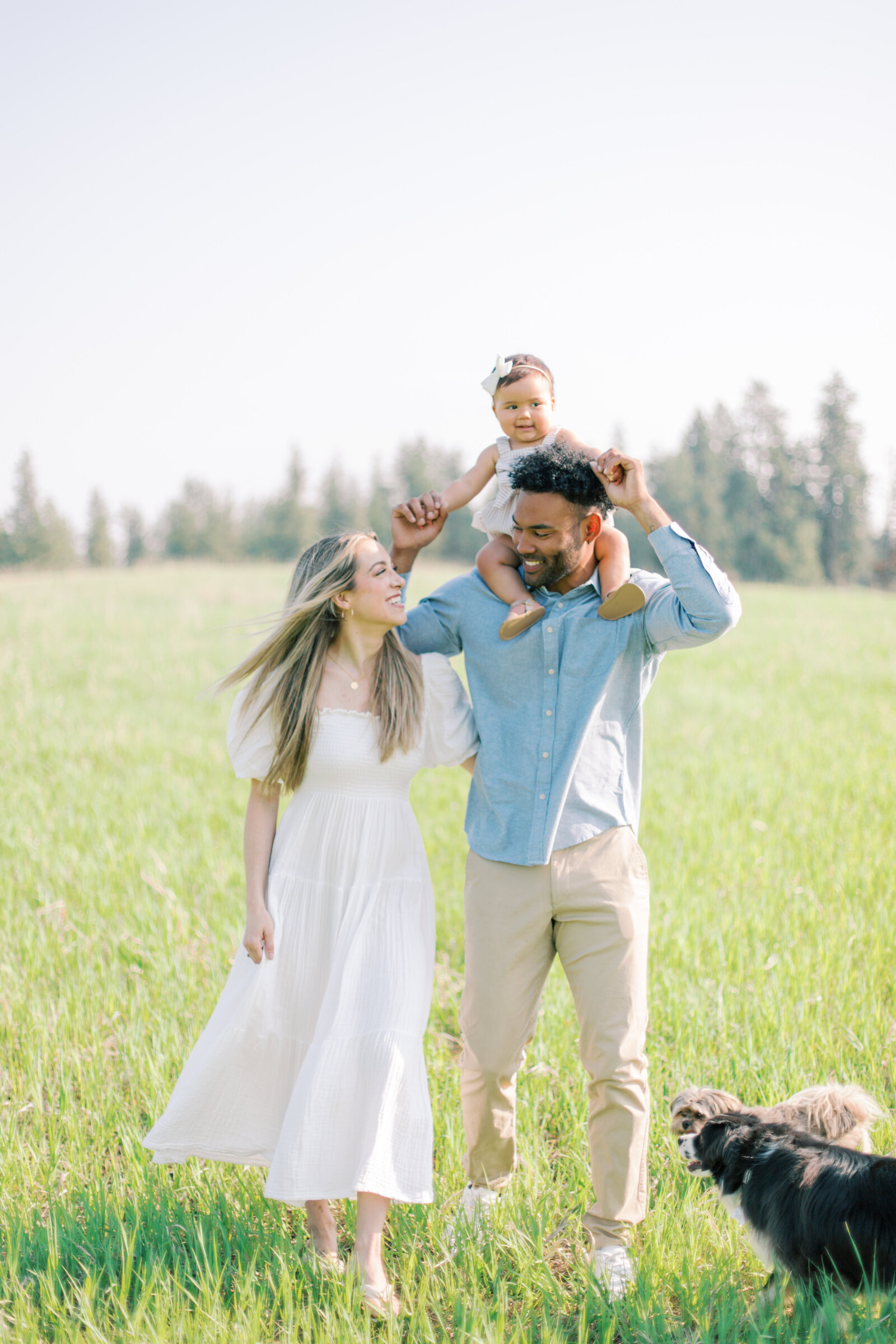 photo of mom and dad with daughter and dogs walking at james t slavin spokane taken by spokane family photographers