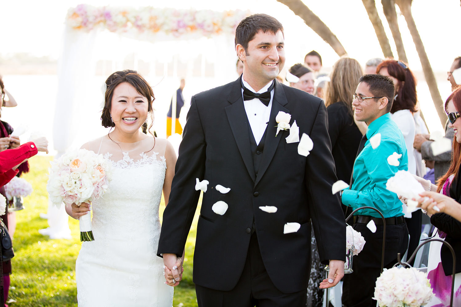 bride and groom walking down the aisle with rise petals