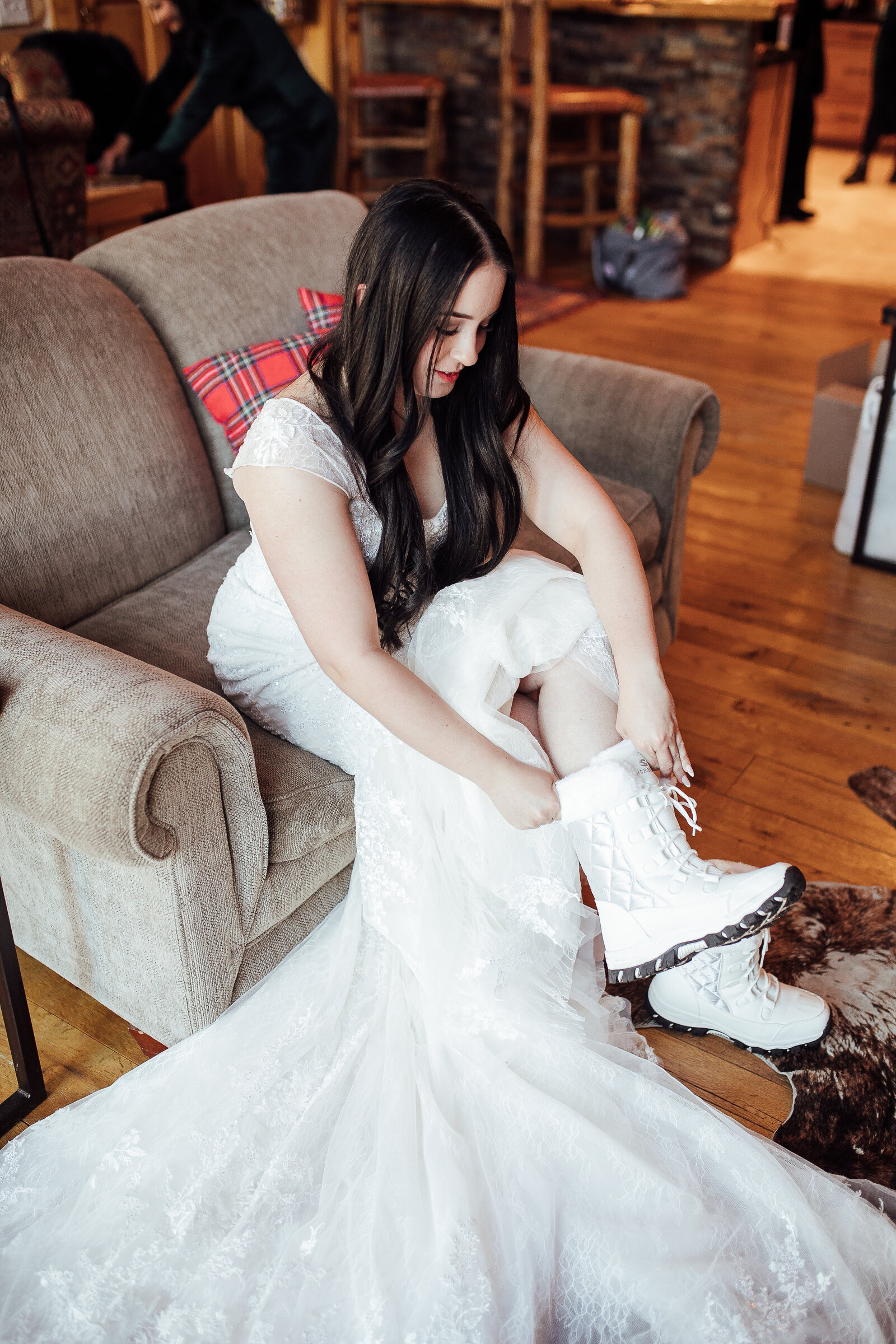 Bride ties winter boots before ceremony