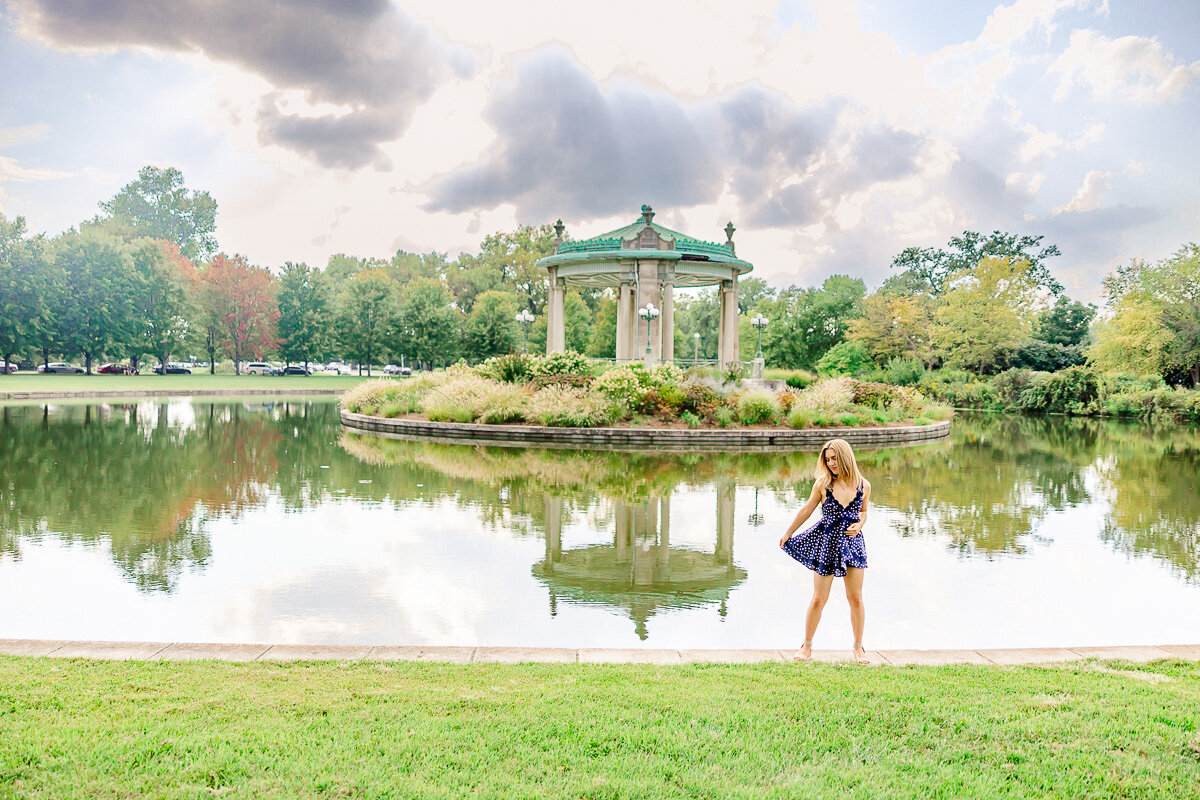 landscape photo of a senior twirling her dress in front of the pagoda in forest park st. louis