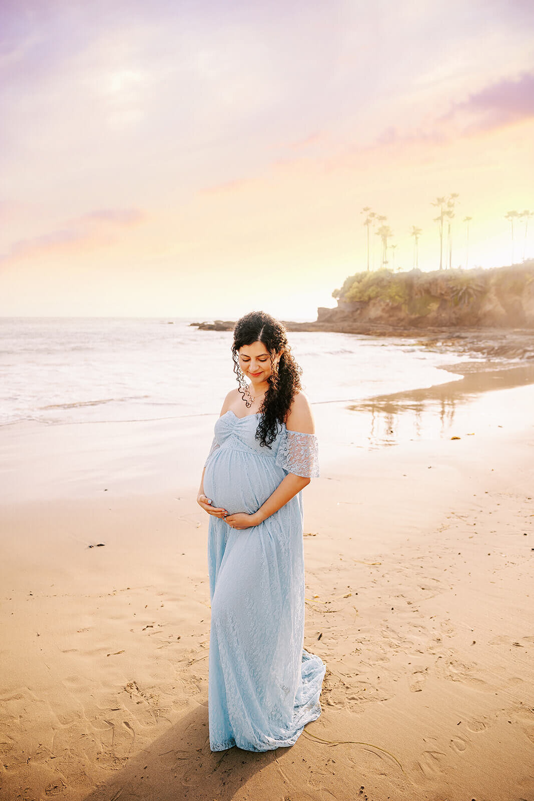 Mom standing on beach in Laguna wearing a blue dress by Ashley Nicole Photography