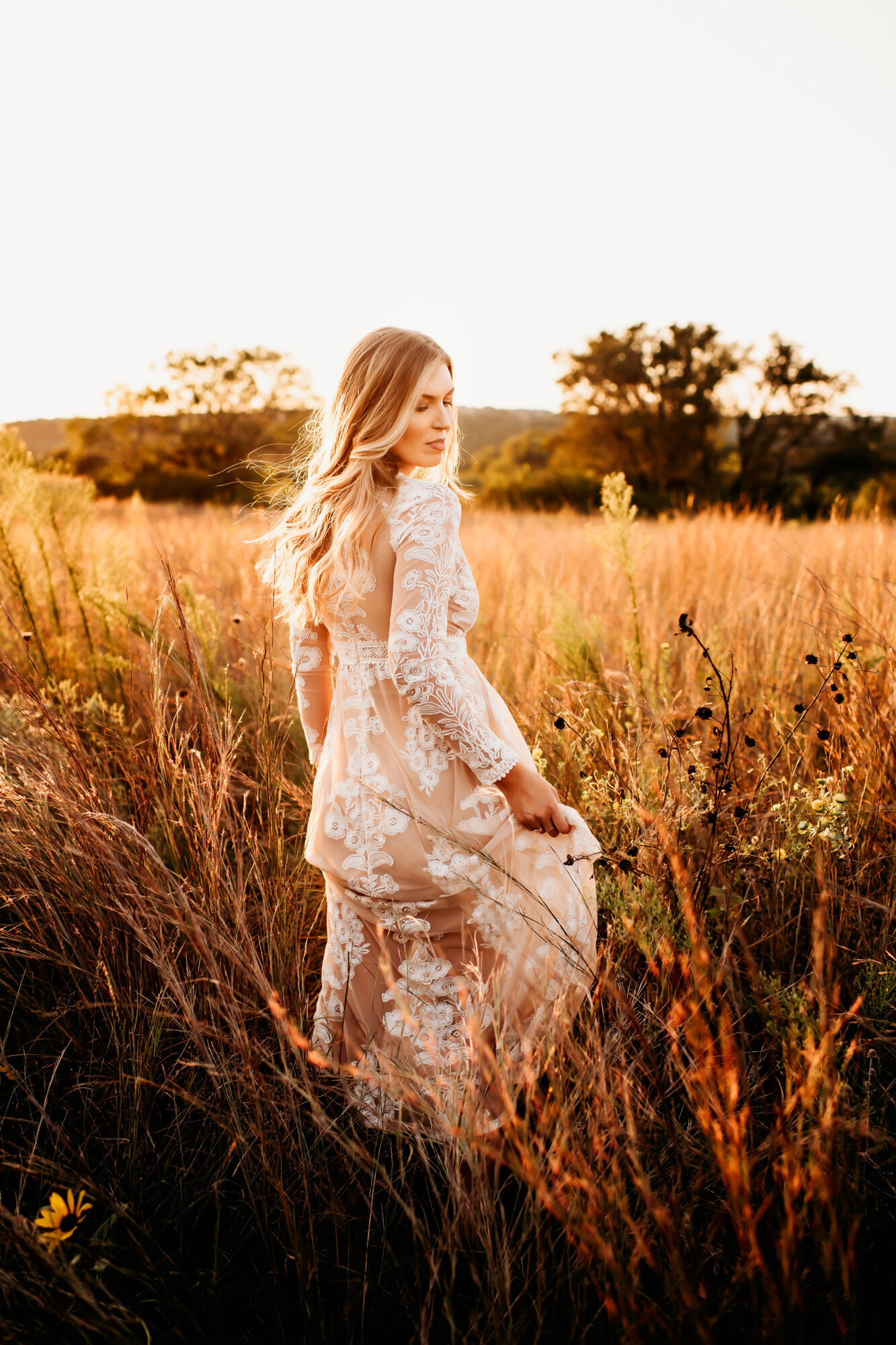 Branding Photographer, a woman holds her dress as she walks through dry grass