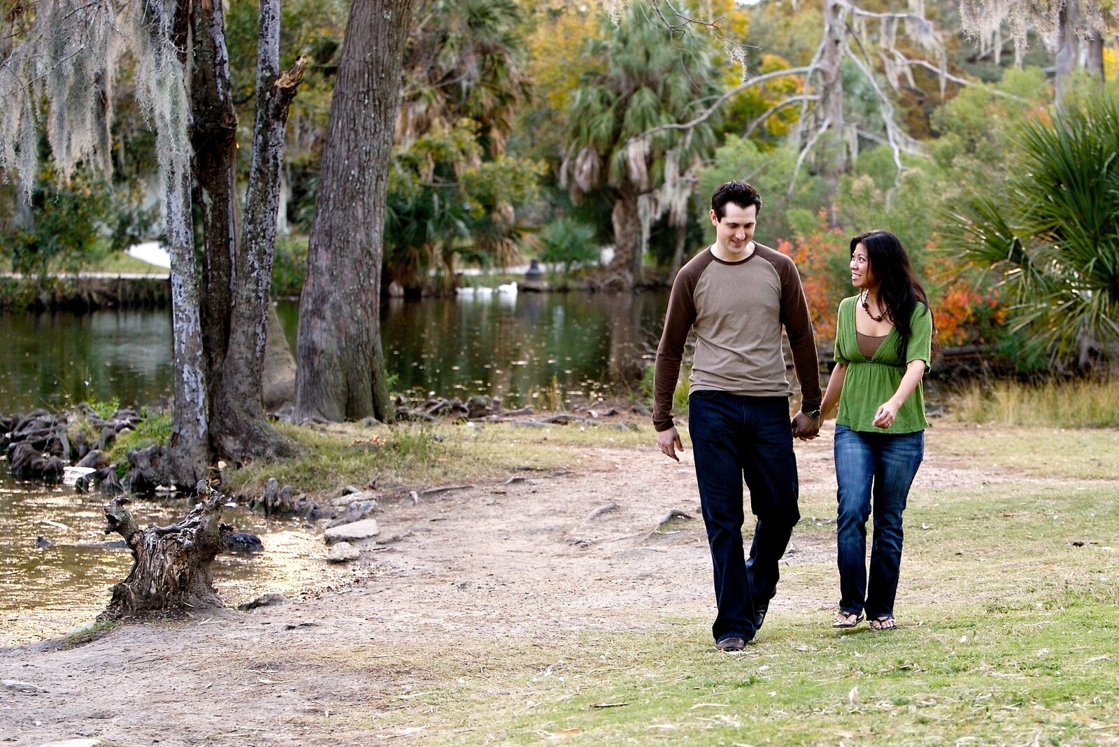 Couple walking in New Orleans City Park during engagement portrait