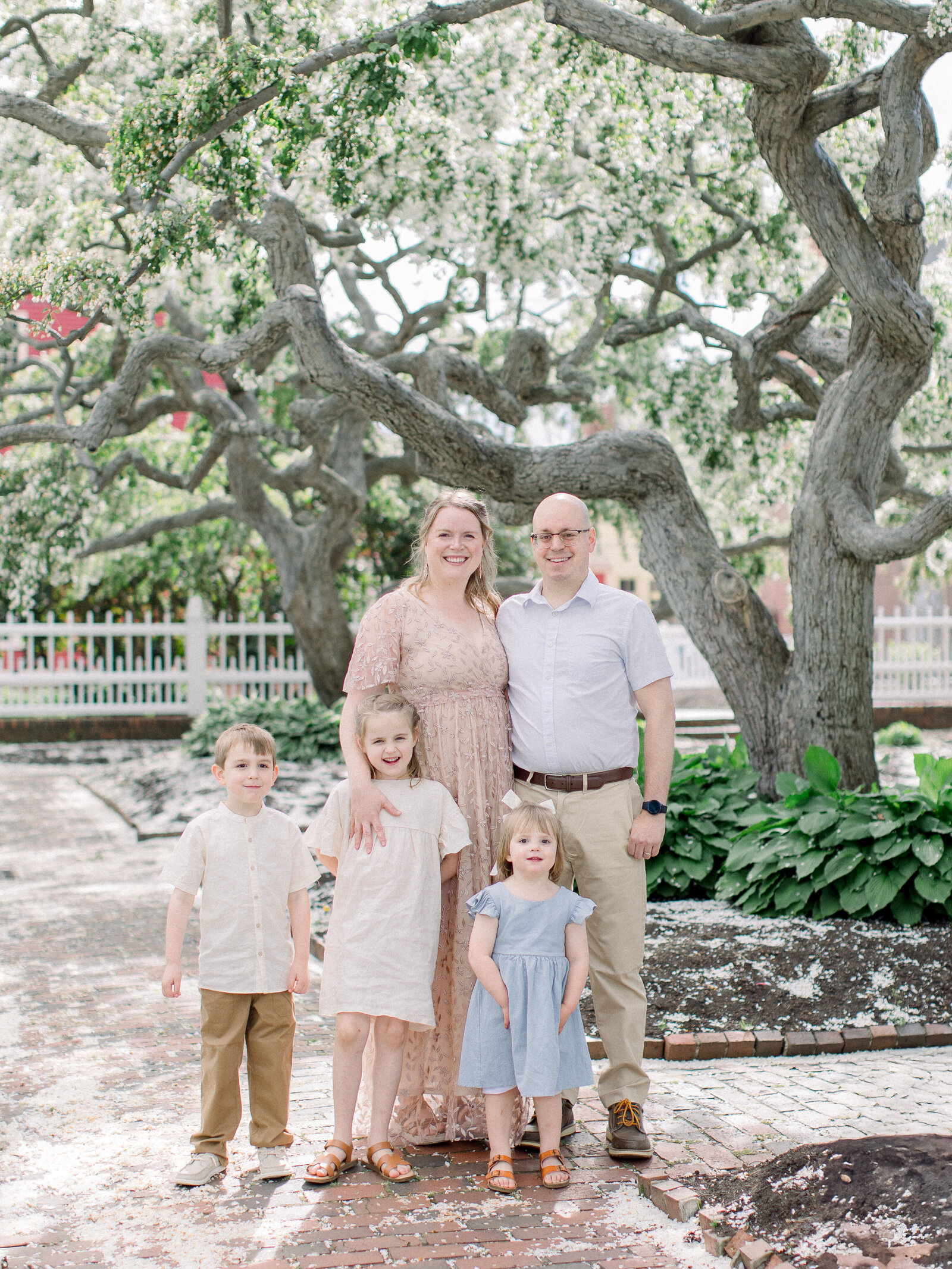 Family of five wearing champagne, ivory, blue and grey together in a spring garden by NH newborn photographer Fieldstone Studio. 