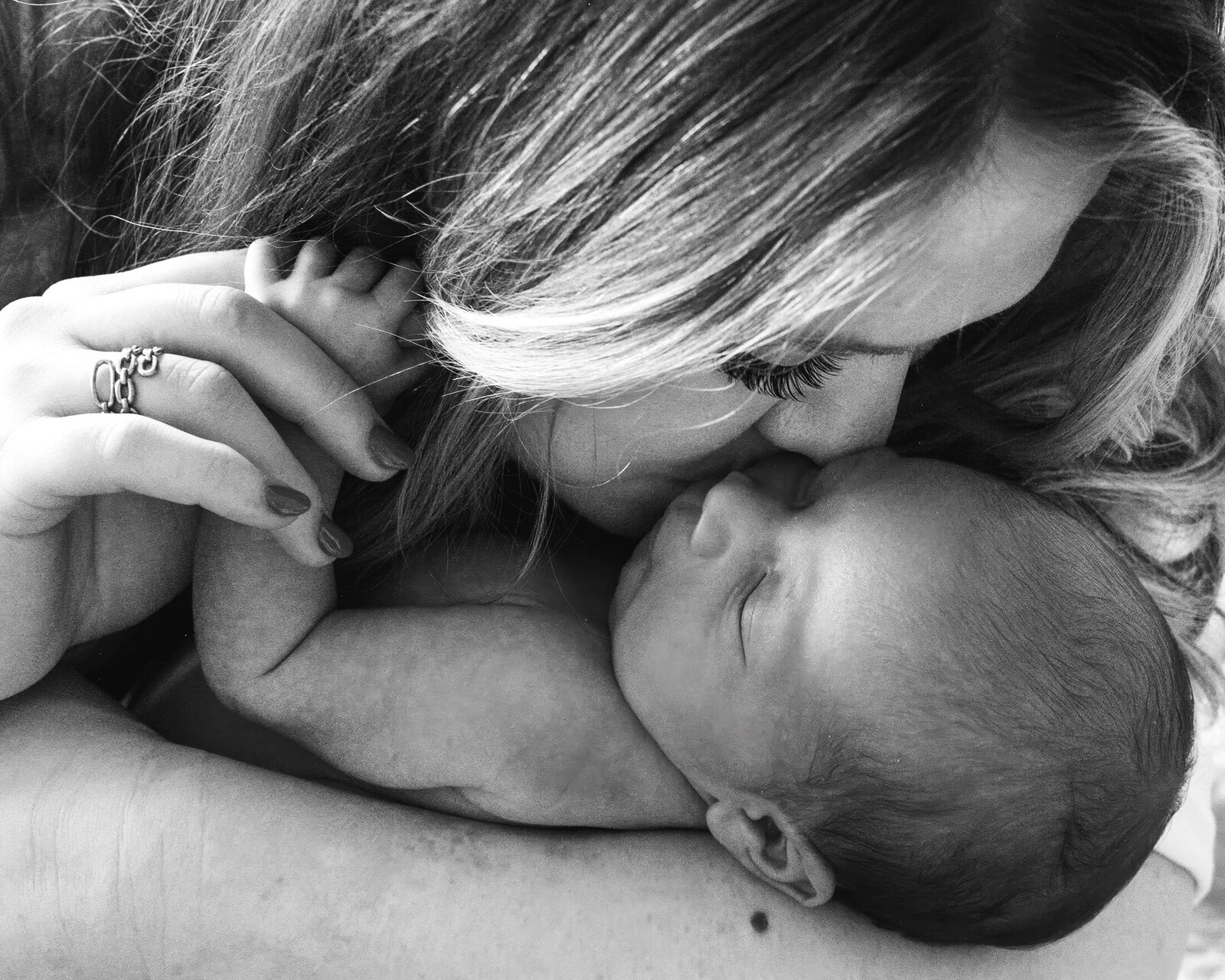 up close of mother kissing her newborn baby reno