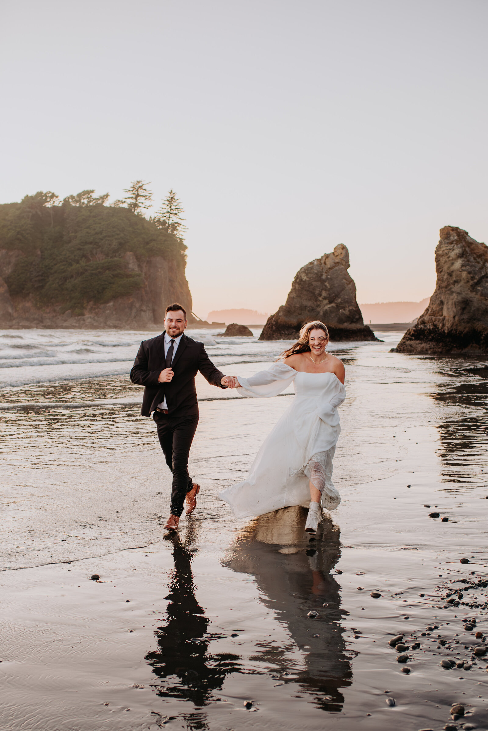 Wedding couple holding hands and running on the beach