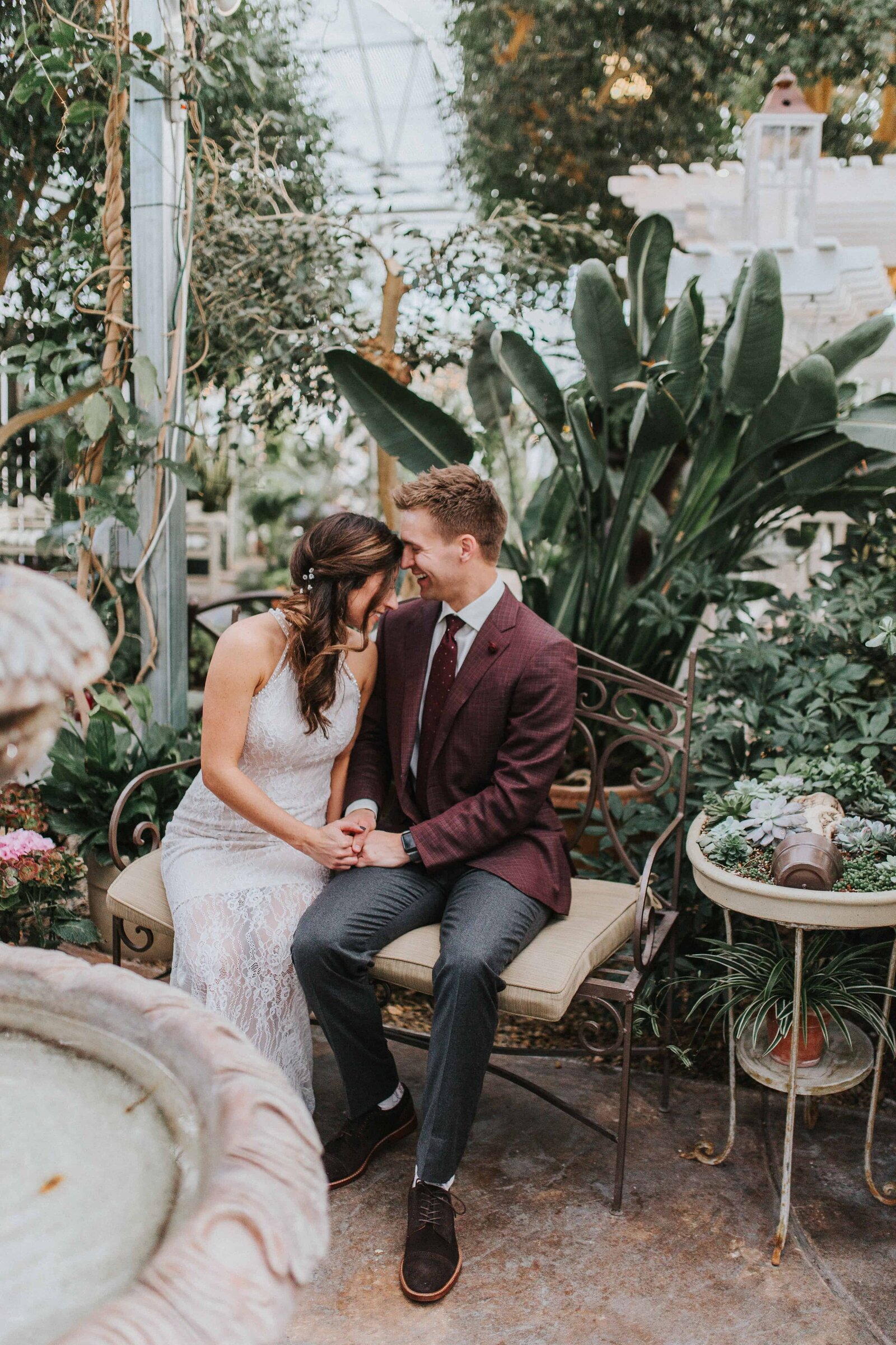 Sacramento Wedding Photographer captures bride and groom laughing together inside greenhouse
