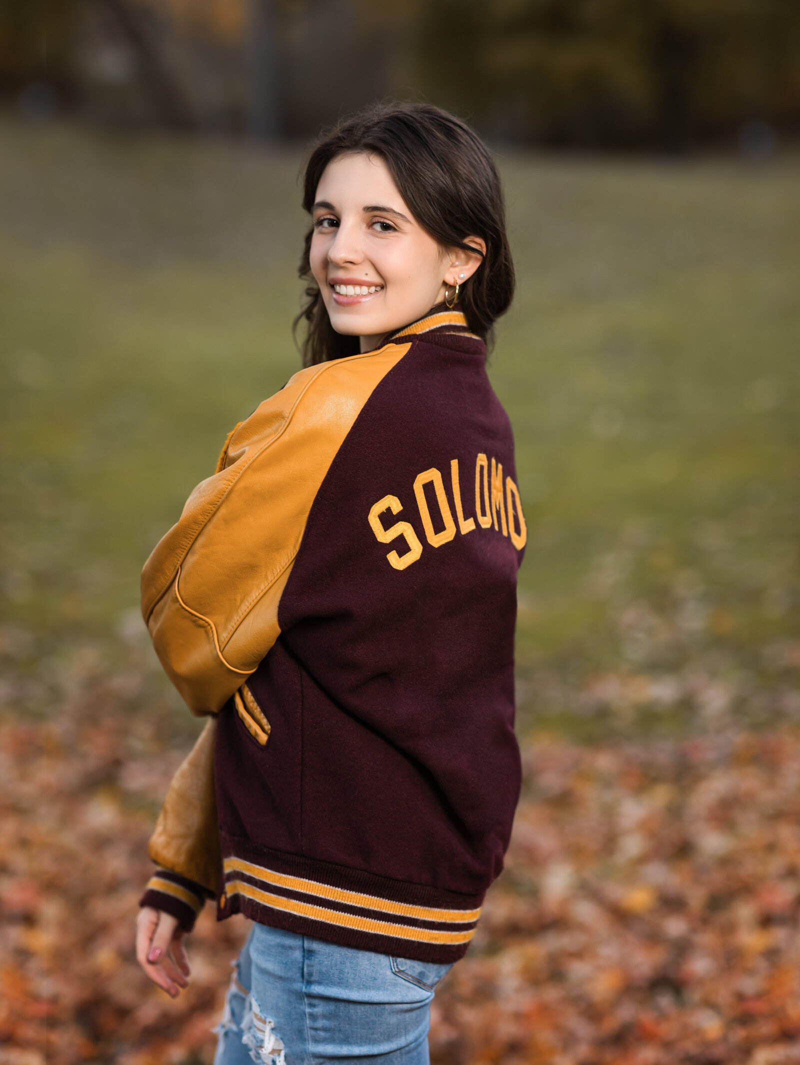 senior girl posing in letterman jacket for senior portraits Cleveland senior photographer