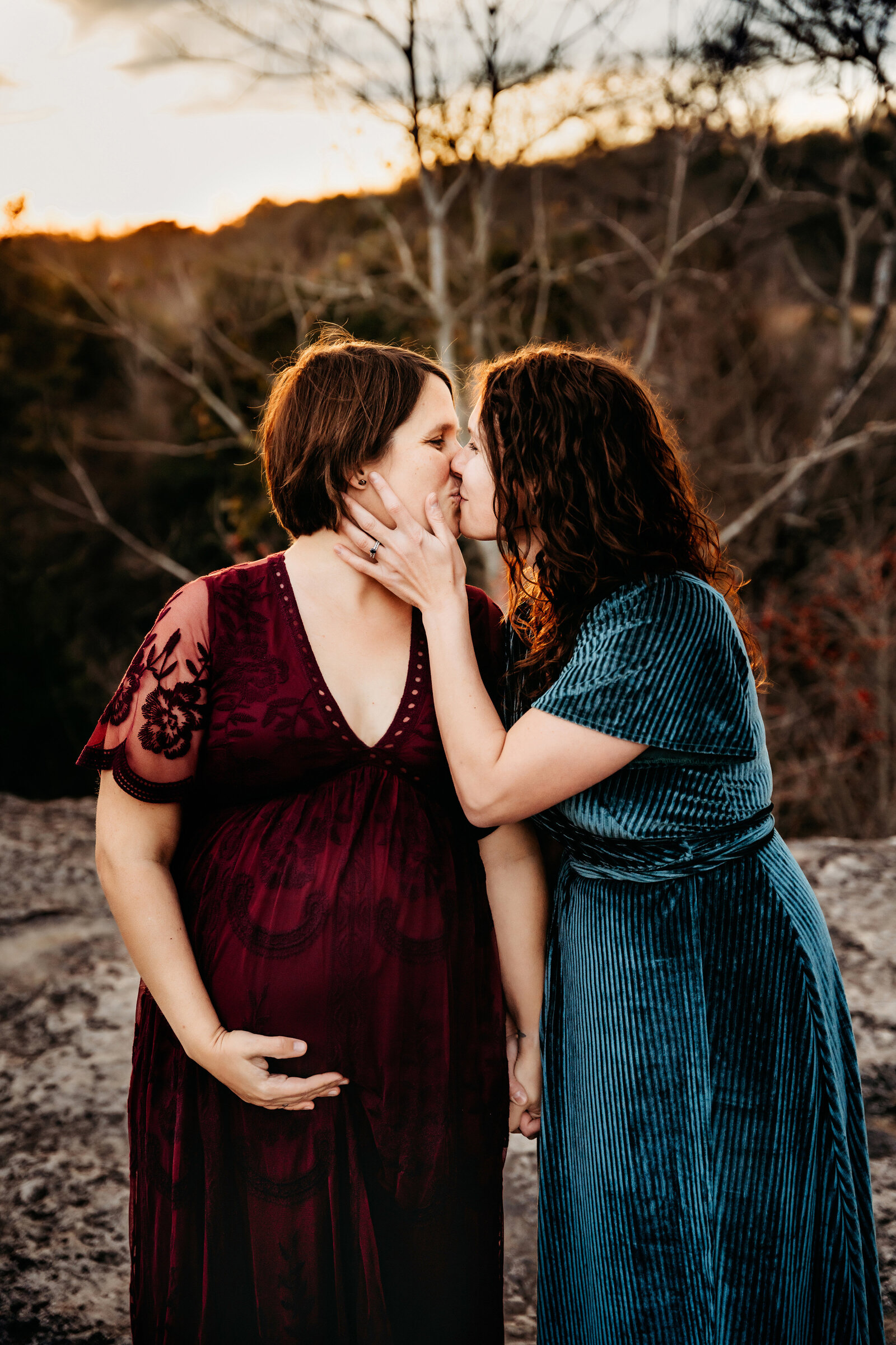 Maternity Photographer, a woman kisses her wife who is pregnant