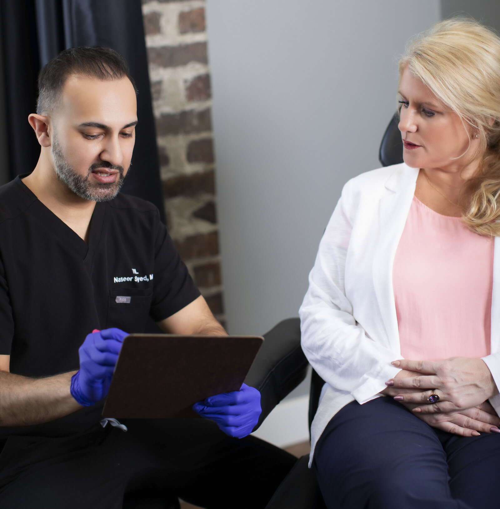 Client receiving honest aesthetic advice from Dr. Syed during pre-treatment consultation