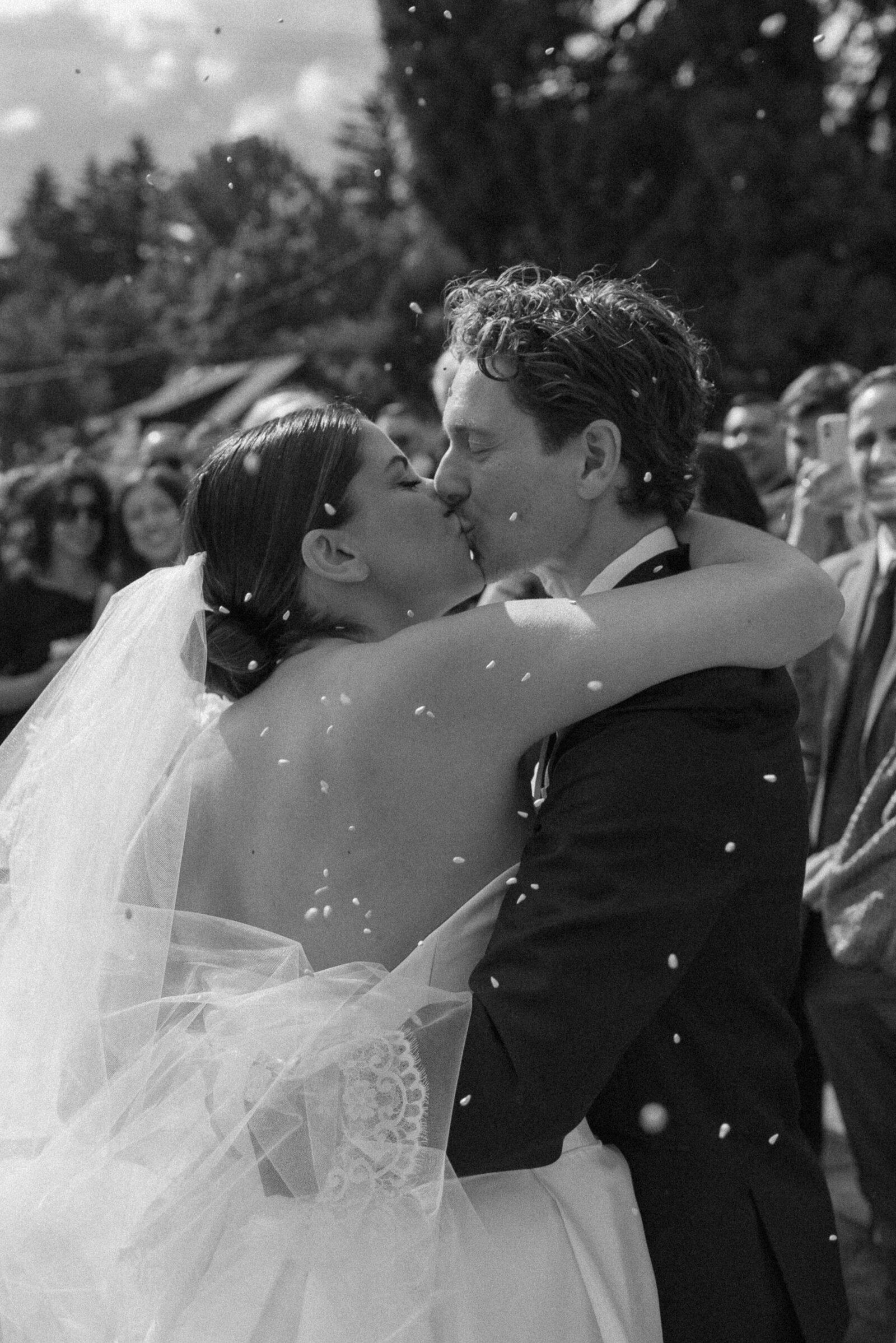black & white photo of bride and groom kissing