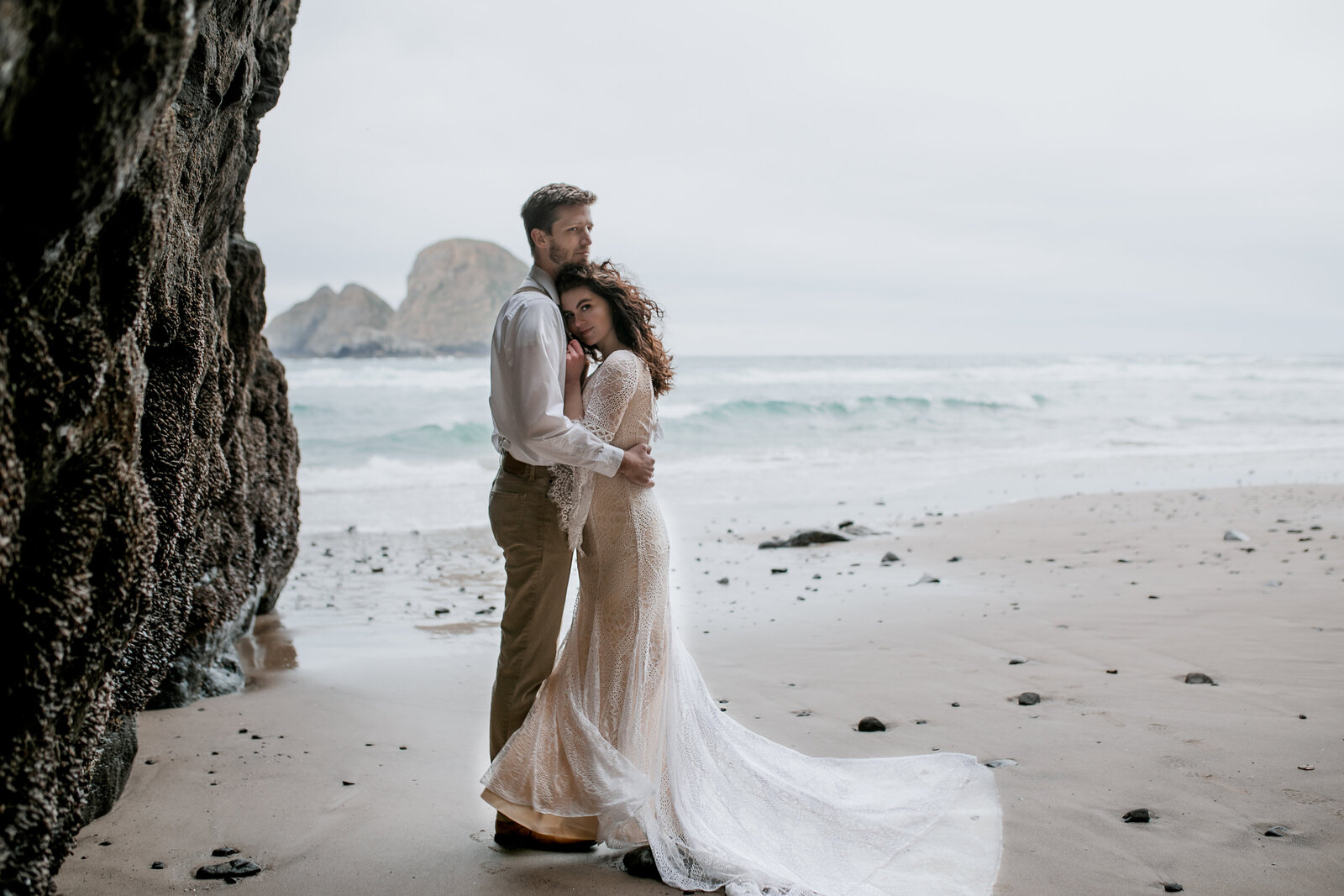 Bride standing on the beach with cliffs in the background, showcasing styled shoots for adventurous photographers in the Pacific Northwest.