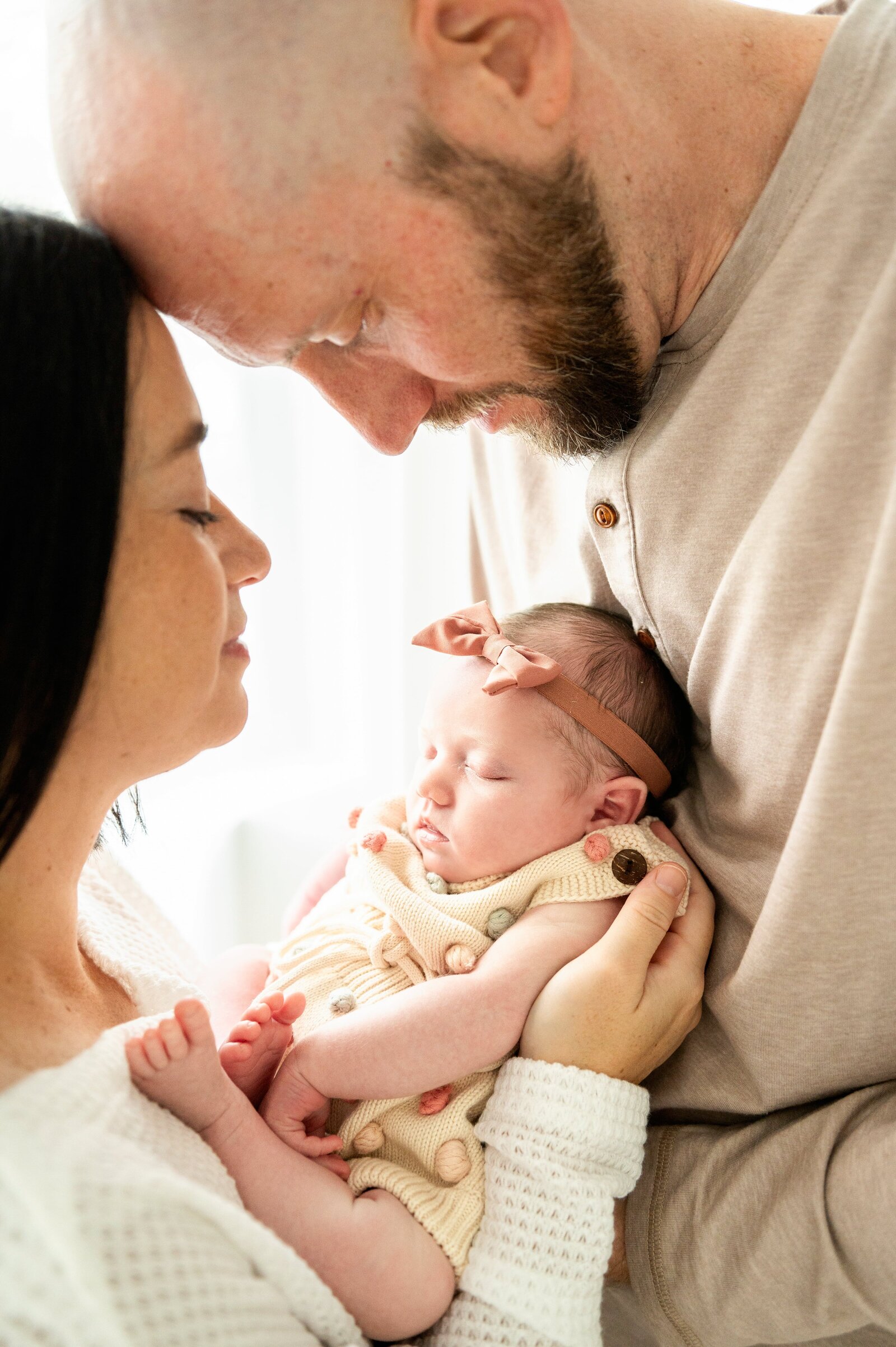 mom and dad looking at newborn baby in a photography studio