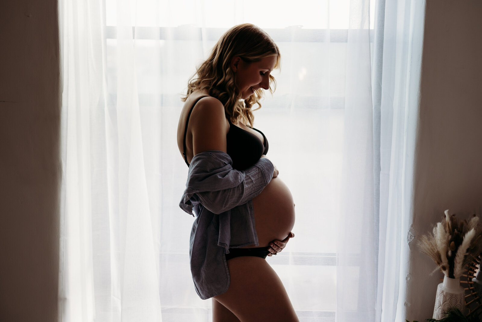 Semi silhouette of pregnant woman in front of window