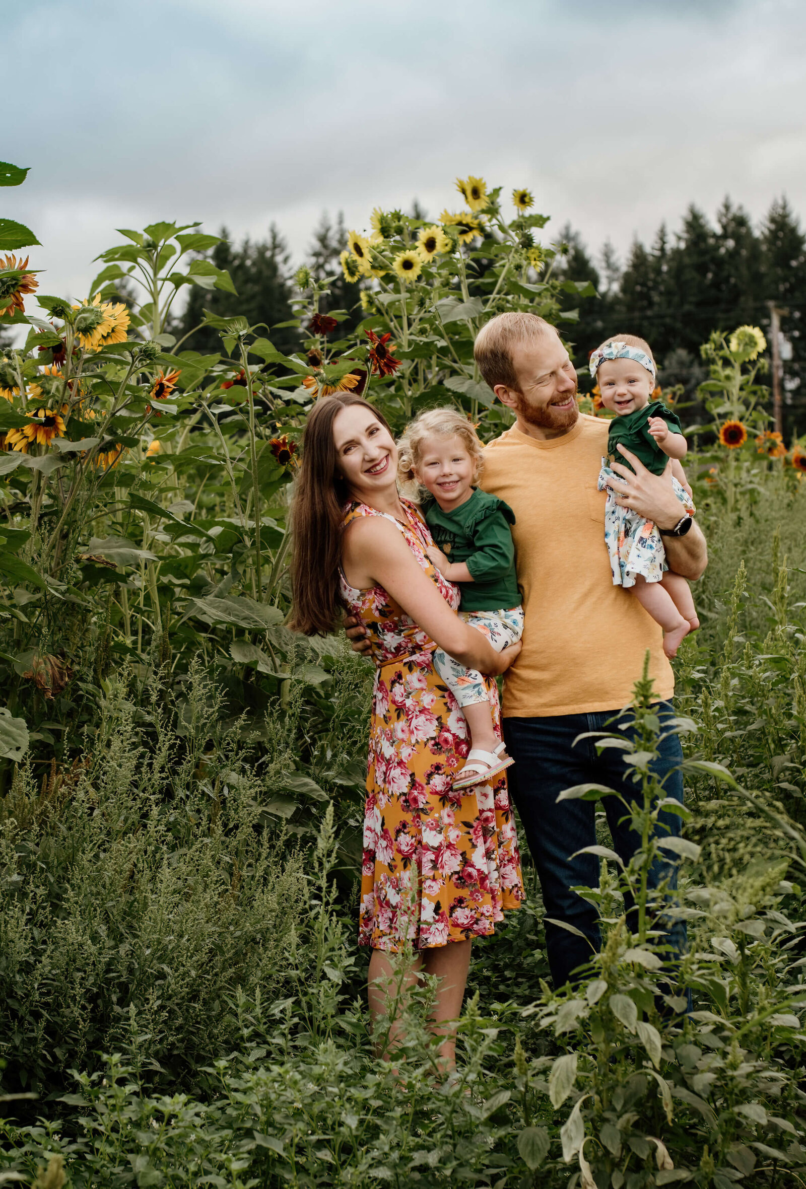Family standing in a sunflower field.